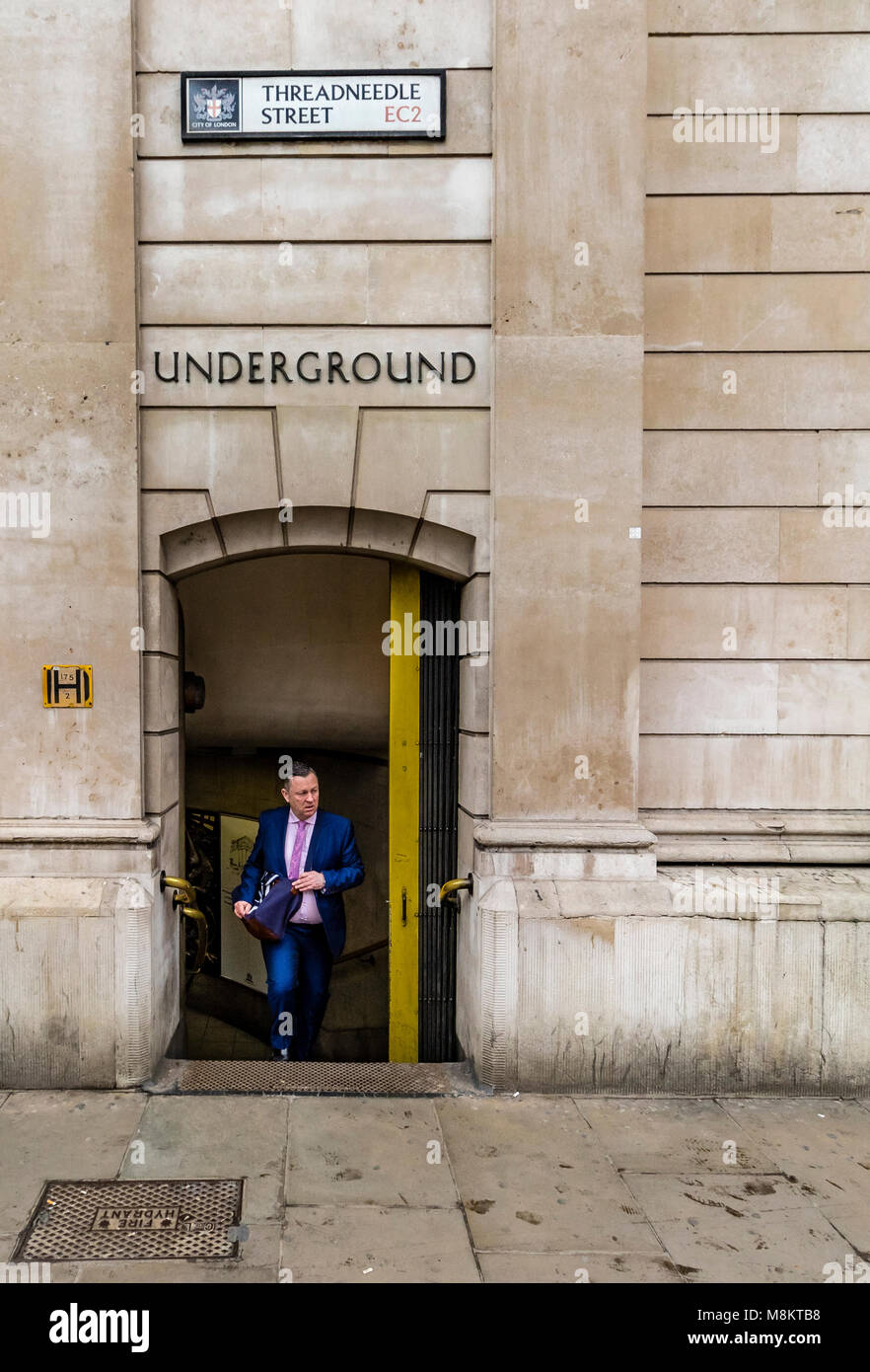 Un lavoratore cittadino corre fino i passaggi alla stazione di Bank su Threadneedle Street , City Of London , REGNO UNITO Foto Stock