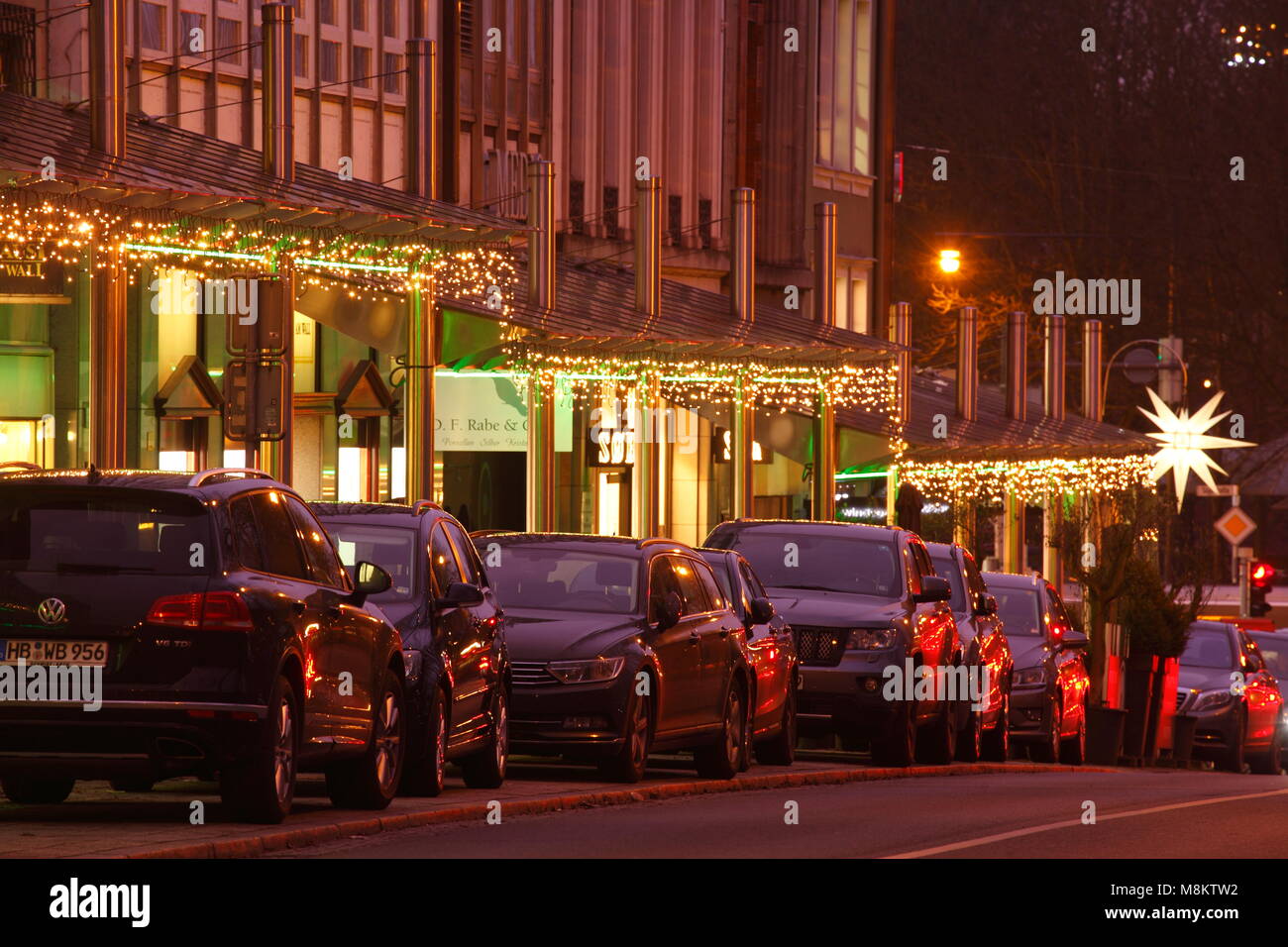 Parcheggio auto con la strada dello shopping di am parete con luci di Natale con il crepuscolo, Brema, Germania, Europa mi Parkende Autos mit Einkaufsstraße Am Wall Foto Stock