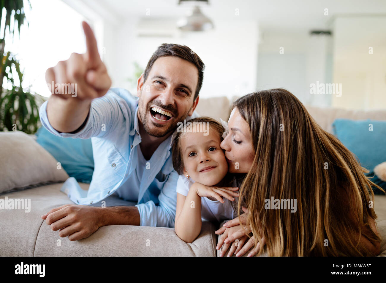 La famiglia felice guardando la televisione a casa loro Foto Stock