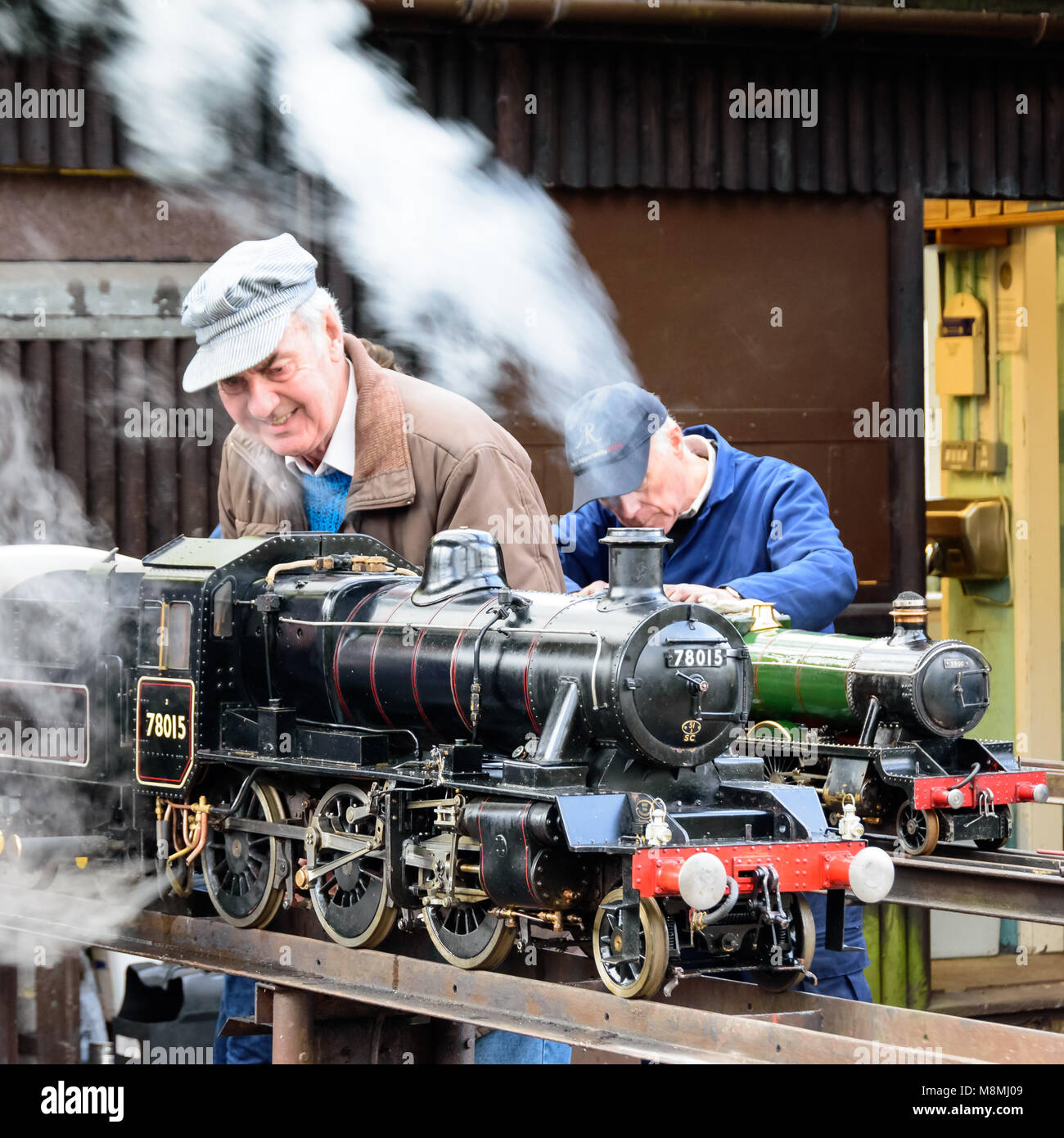 Due appassionati lavorano sui loro modelli di motori a vapore al Lodge Park, Frimley Foto Stock