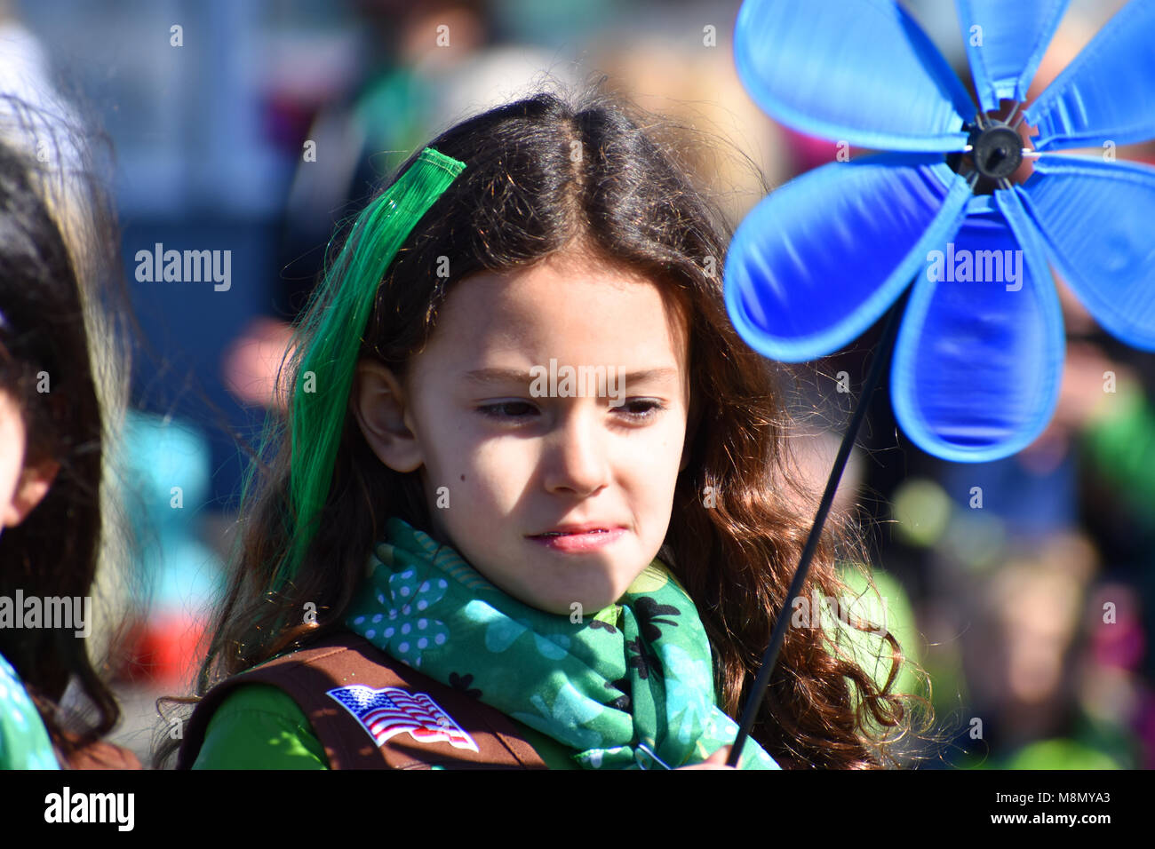 Una giovane ragazza scout in Bellingham, WA. La festa di san Patrizio parata del 17 marzo 2018. Una bandiera americana patch è sulla sua spalla - tenendo un fiore spinner. Foto Stock