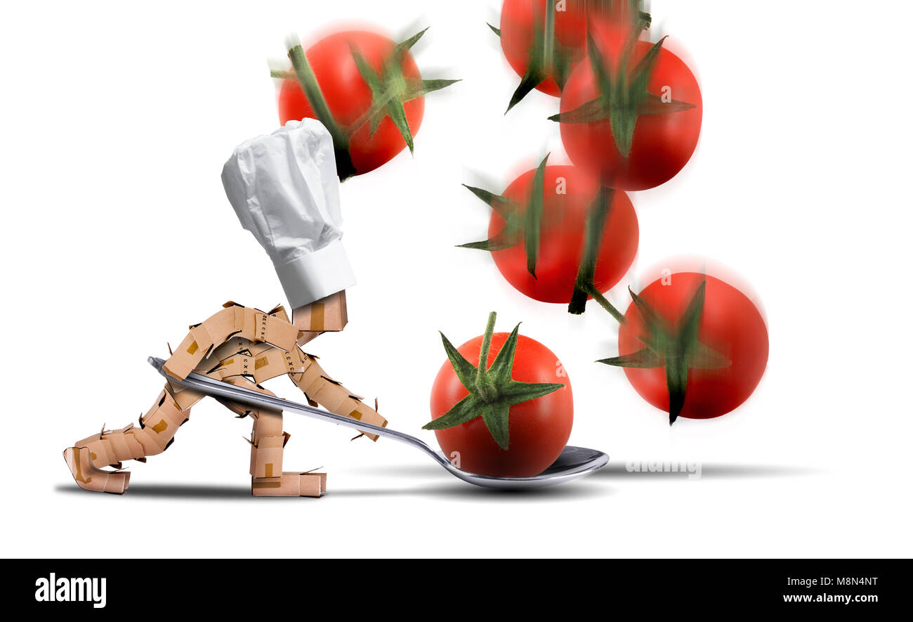 Lo Chef carattere cassa tenendo un cucchiaio grande cattura i pomodori durante la loro caduta. Cappello bianco e lo sfondo bianco. La cottura, lavoro e concetto di cibo. Foto Stock