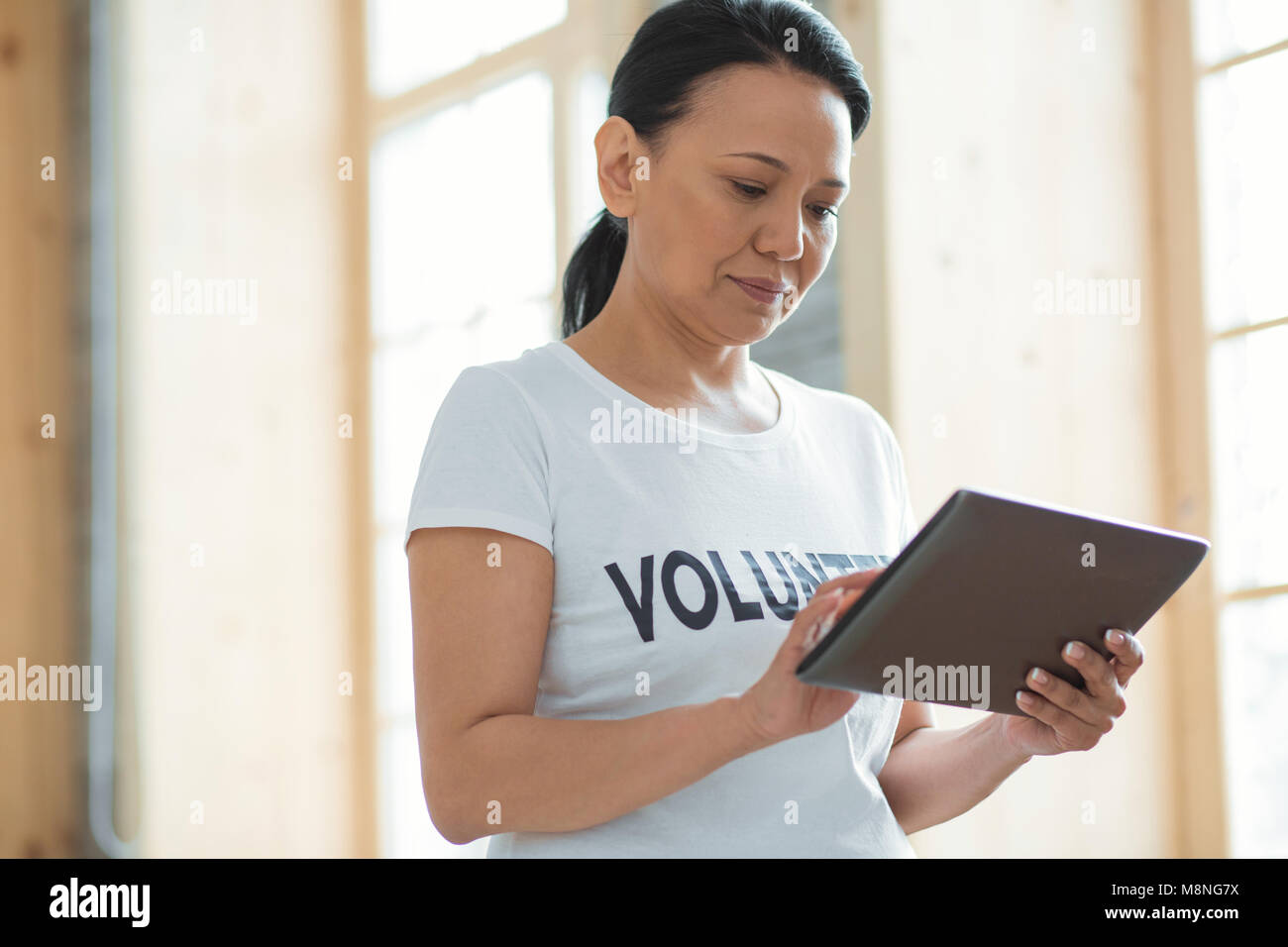 Attraente volontario femmina messaggio di digitazione Foto Stock