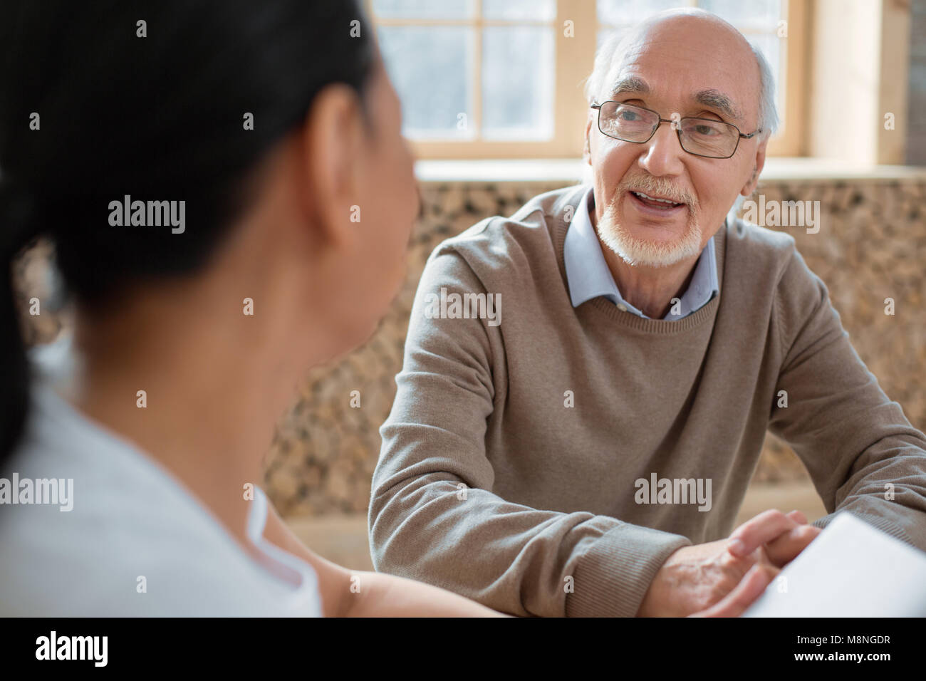 Volontari e gioiosa uomo senior per condividere pensieri Foto Stock