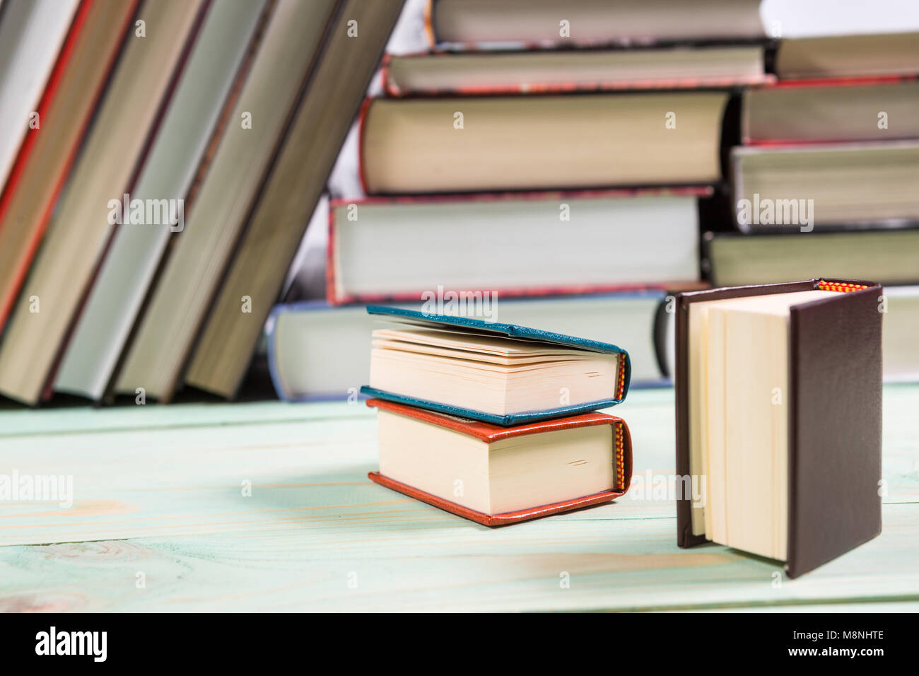 Pila di libri sullo sfondo di legno Foto Stock