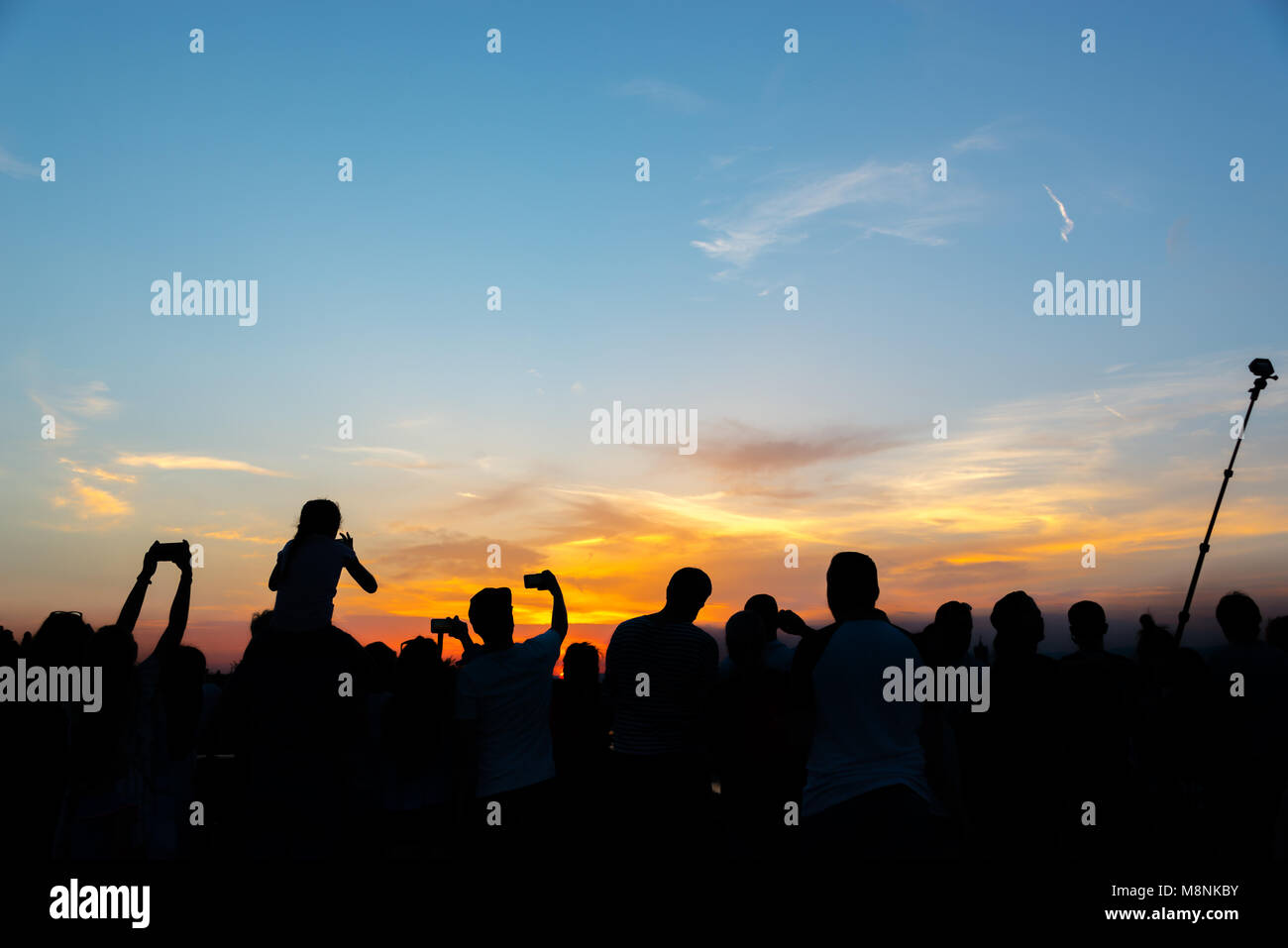 La folla di gente di fotografare il tramonto con telefoni cellulari e selfie stick su una notte d'estate a Firenze, Italia Foto Stock