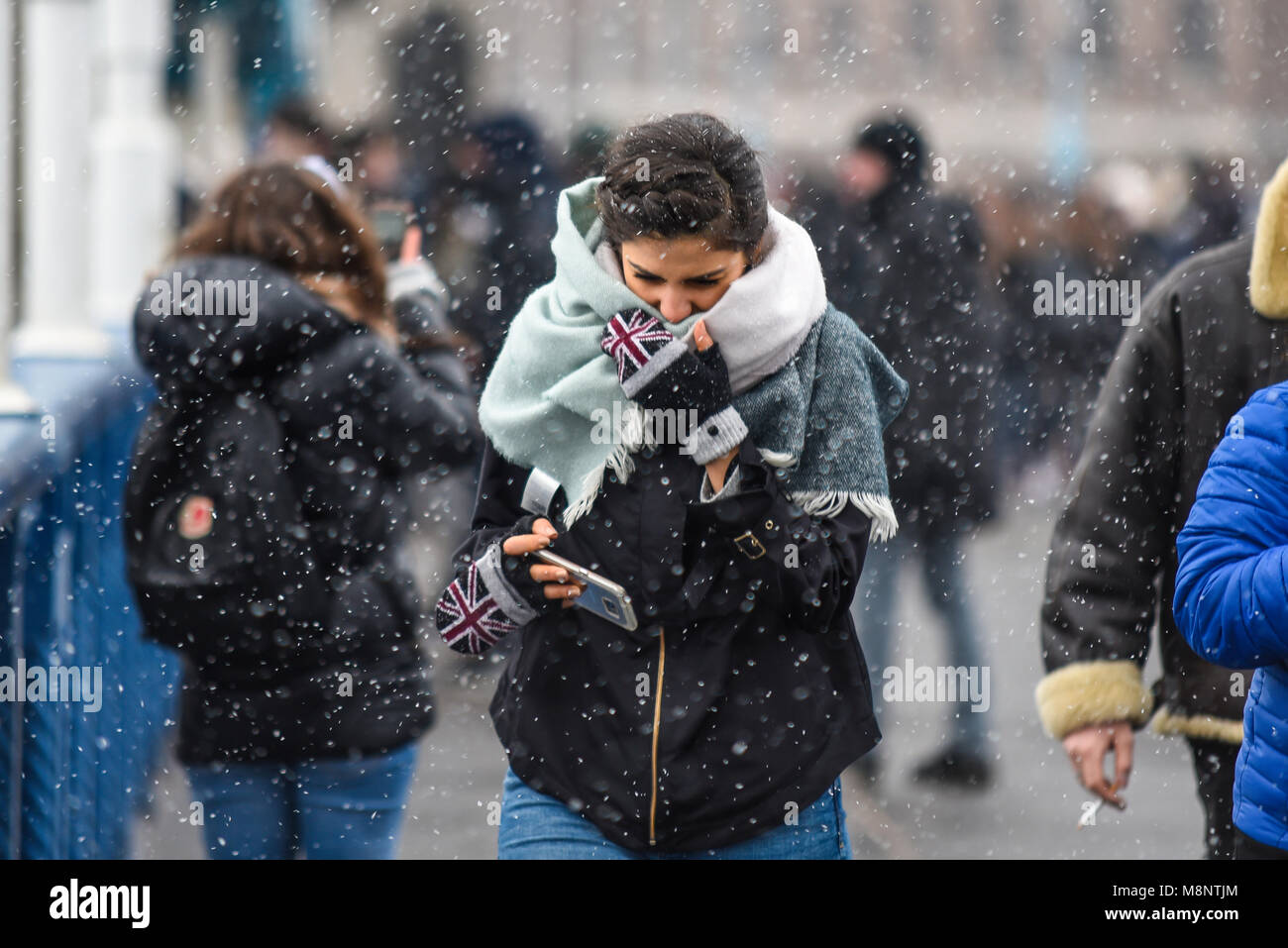 Femmina con britannica Union Jack guanti in tempesta di neve a Londra. Mini Bestia da est a nevicare. Freddo. Invernale. L'inverno. Congelati. Ragazza. La donna. Persona Foto Stock