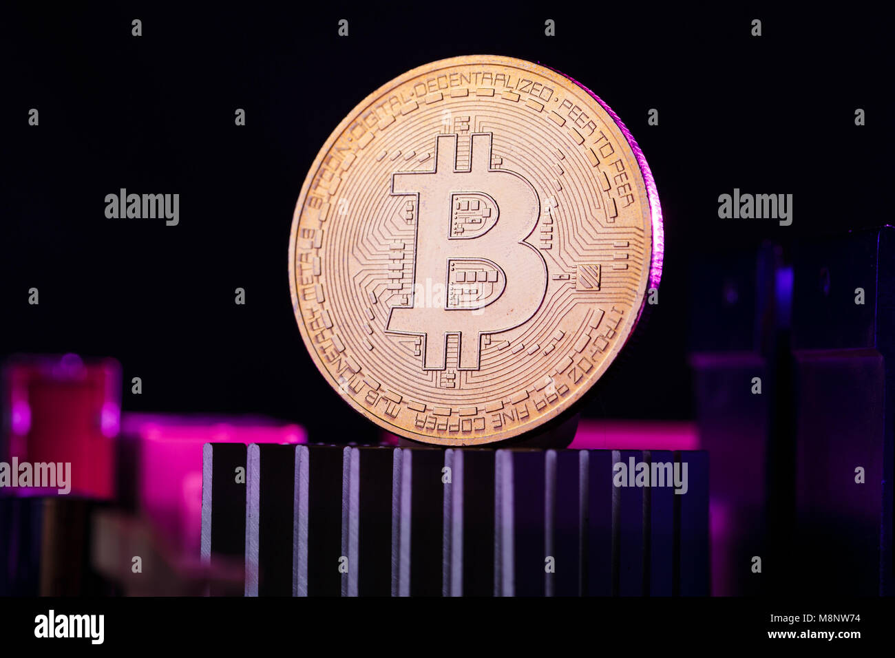 Foto di moneta virtuale, bitcoin e processore su sfondo rosa Foto Stock