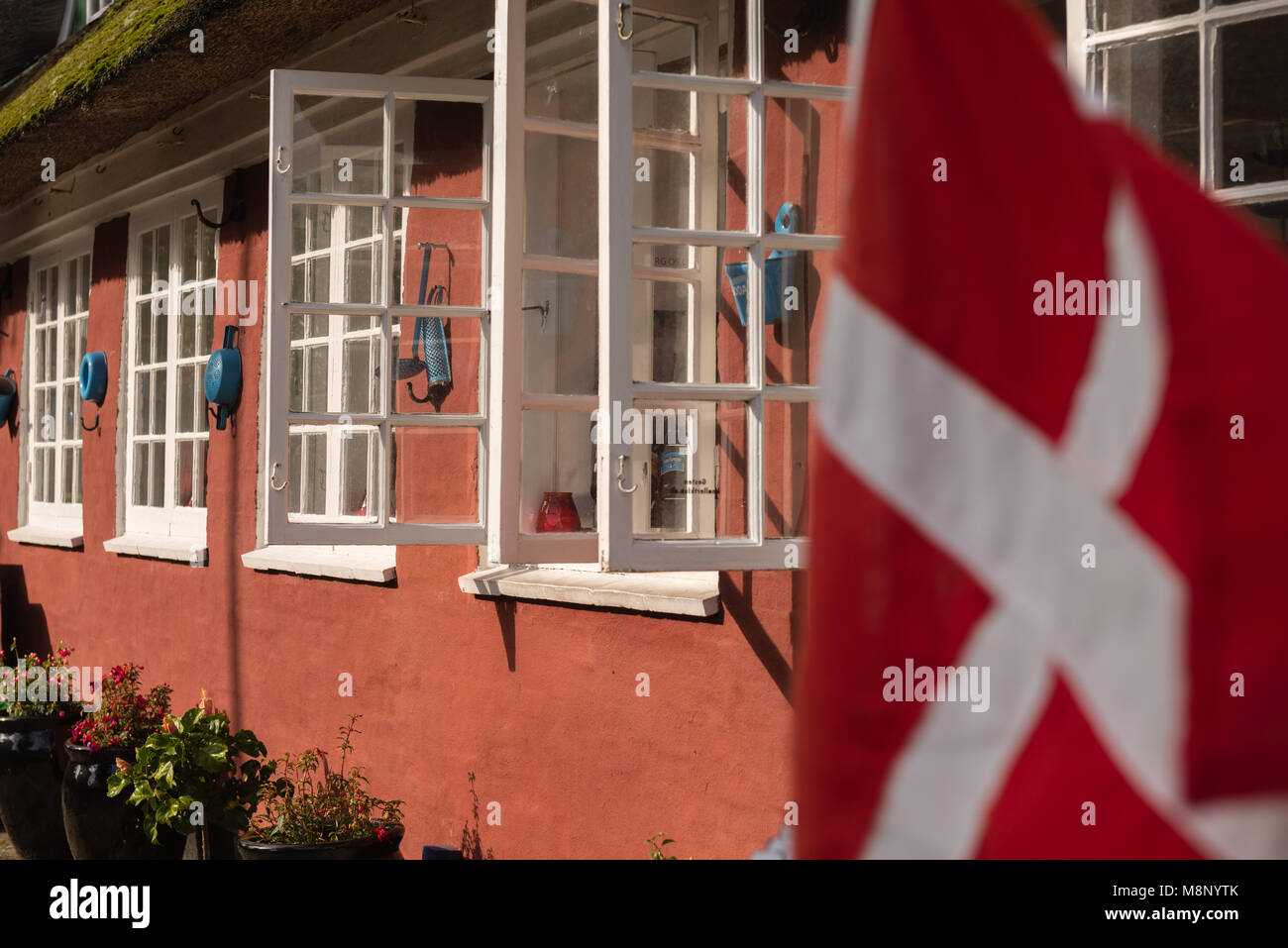 Tipica casa danese in Nordby, bandiera danese, isola di Fanoe, Mare del Nord, nello Jutland, Danimarca e Scandinavia Foto Stock