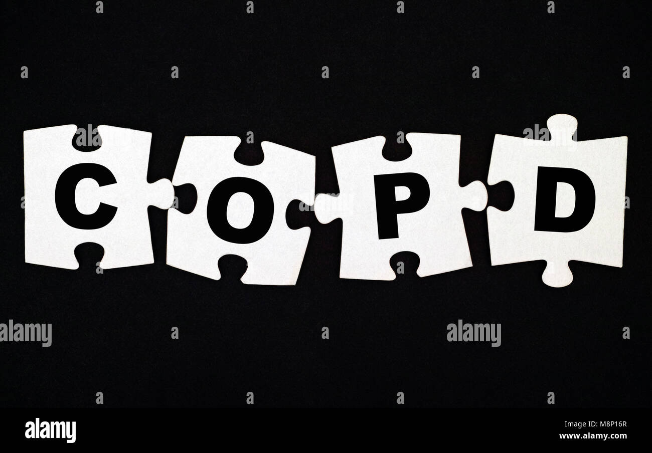 Quattro pezzi di un puzzle con lettere COPD su sfondo nero. Foto Stock
