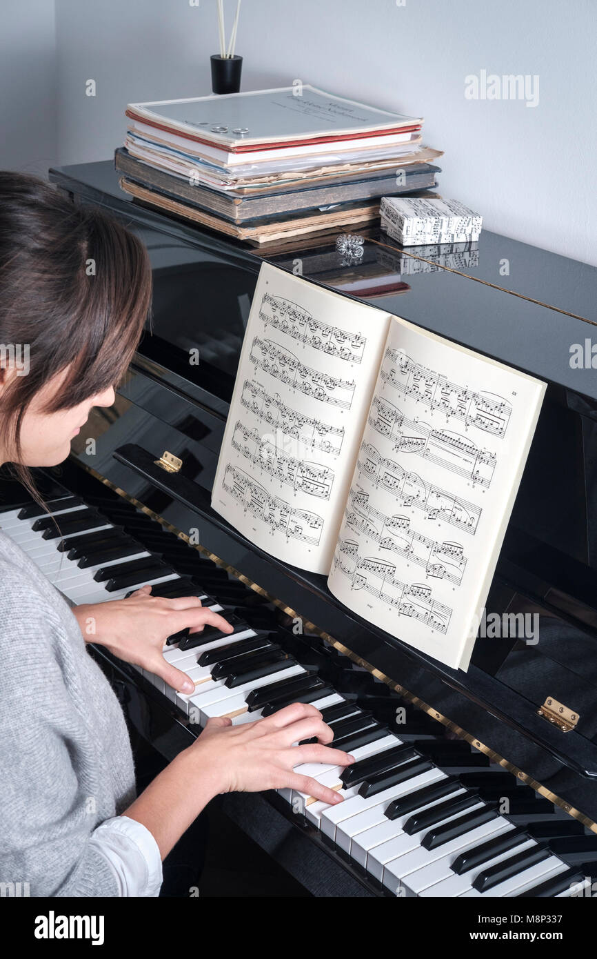 Donna suona il pianoforte lettura musicale cliente Foto Stock