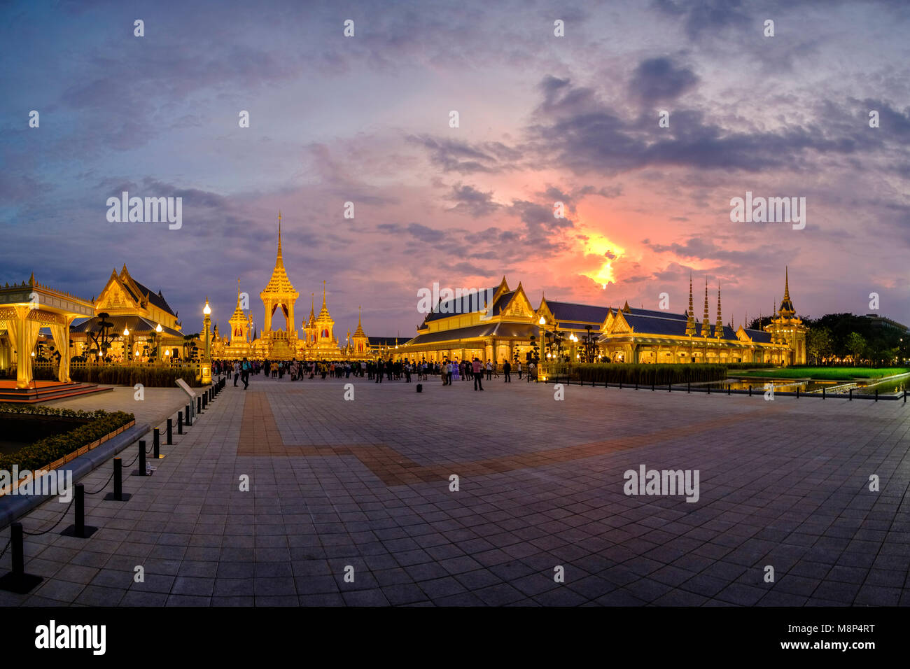 Persone in lutto sedersi di fronte al royal illuminato crematorio e complesso funebre dopo la morte del re Bhumibol Adulyadej di notte Foto Stock