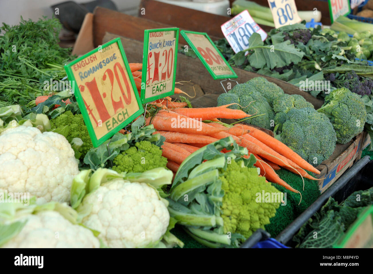 Fruttivendolo mercato trader di stallo di verdura verde con Cavoli, cavolfiori, carote, broccoli e viola broccoletti. Foto Stock