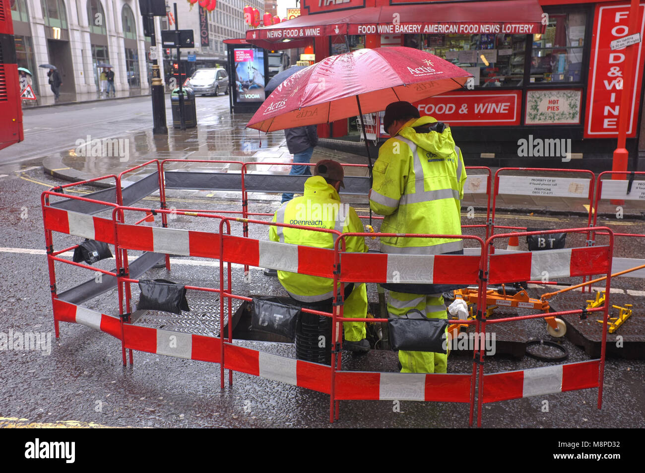 BT aprire raggiungere ingegneri sotto la pioggia a Soho, Londra. Foto Stock