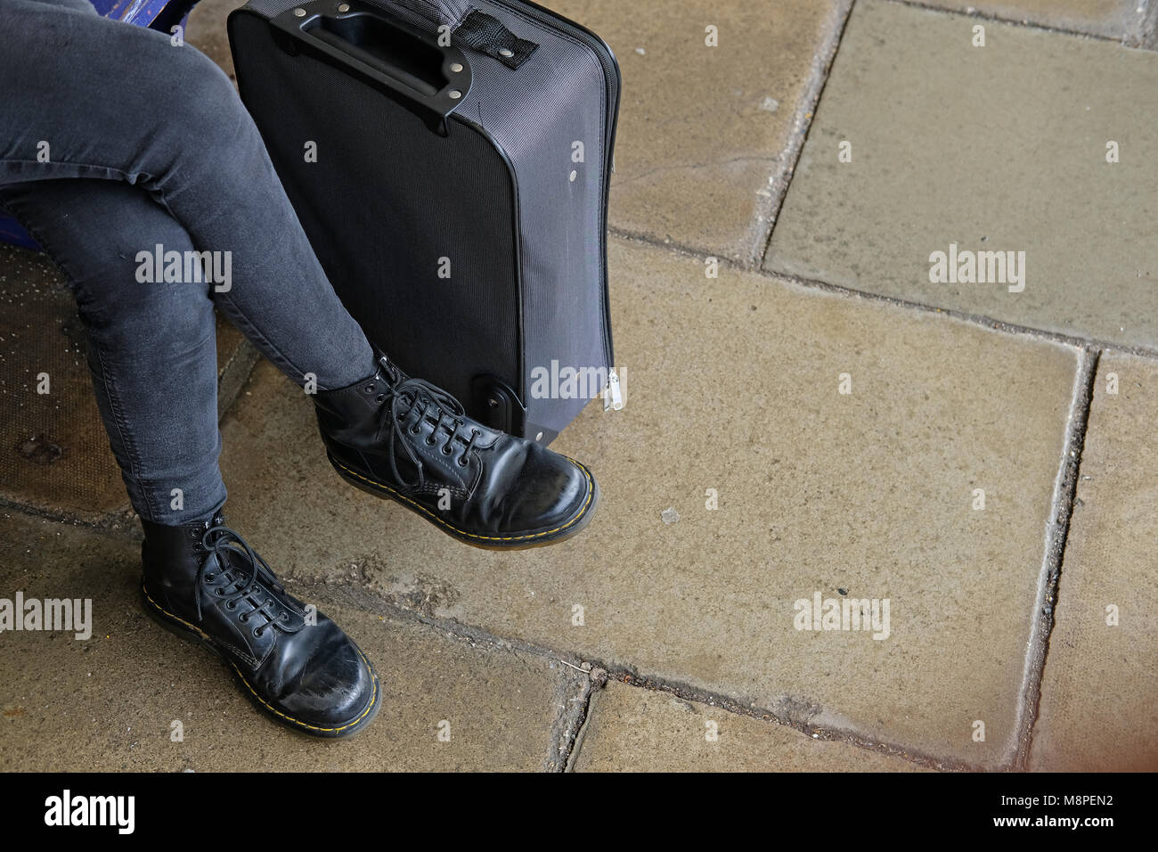 Lo studente che indossa il Dr Martin scarpe con la sua valigia. Foto Stock