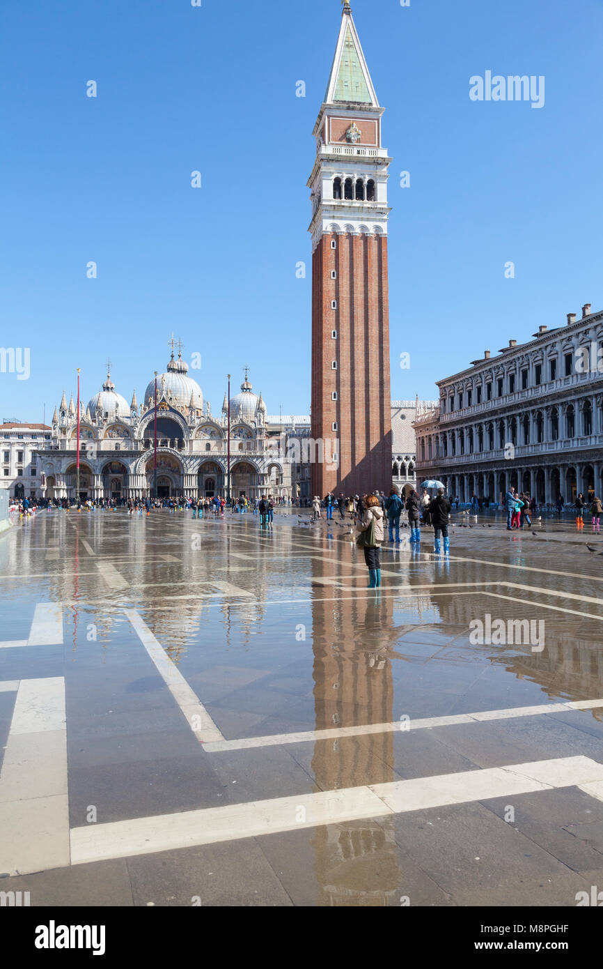 La riflessione del Campanile e di San Marco la Basilica in Acqua Alta, Piazza San Marco, Venezia, Italia. L' acqua era sfuggente e sunshine offerte Foto Stock