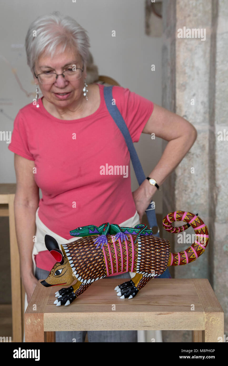 Oaxaca Oax., Messico - un visitatore ammira un alebrije al San Pablo centro culturale. Alebrijes sono scolpiti in legno animali o di fantasiose creature che Foto Stock