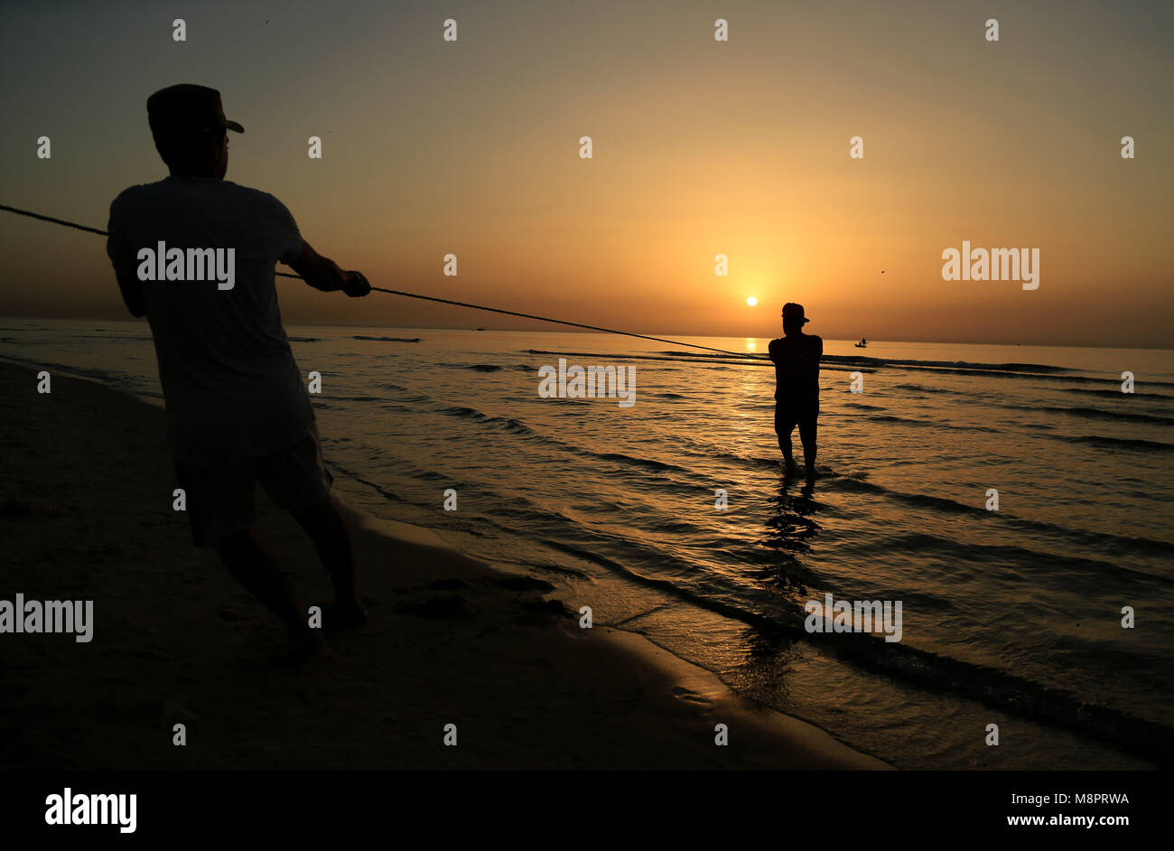 La città di Gaza, Striscia di Gaza, Territori palestinesi. Xix Mar, 2018. I pescatori palestinesi tirare fuori le loro reti da acqua a la spiaggia di Gaza City durante il tramonto su Marzo 19, 2018 Credit: Dawoud Alkas Abo/immagini APA/ZUMA filo/Alamy Live News Foto Stock