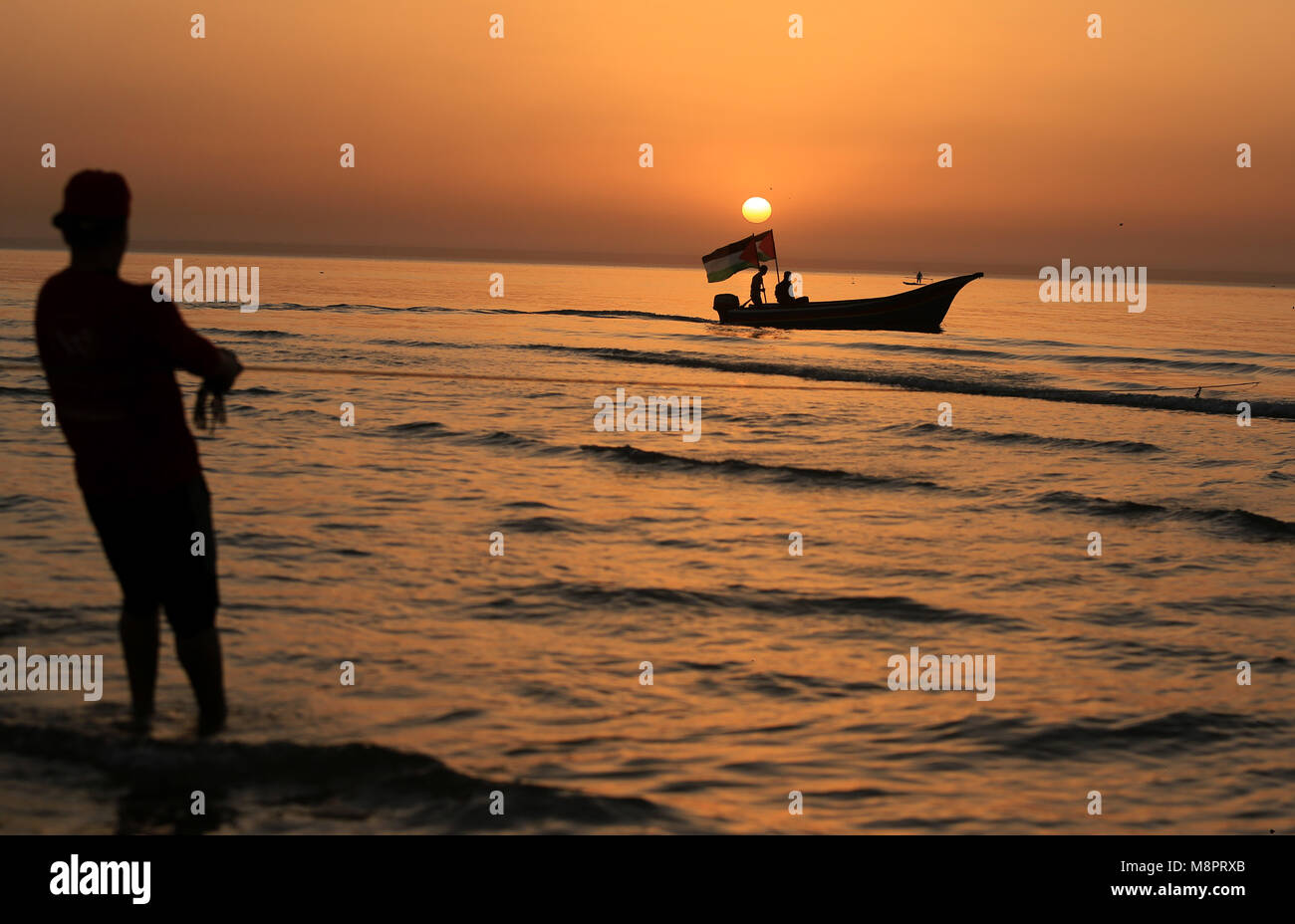 La città di Gaza, Striscia di Gaza, Territori palestinesi. Xix Mar, 2018. I pescatori palestinesi tirare fuori le loro reti da acqua a la spiaggia di Gaza City durante il tramonto su Marzo 19, 2018 Credit: Dawoud Alkas Abo/immagini APA/ZUMA filo/Alamy Live News Foto Stock