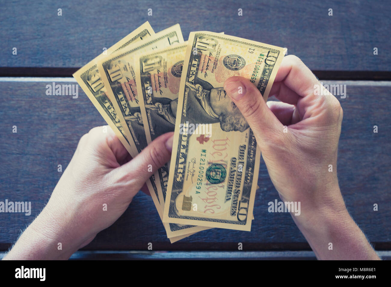 Mani femminili contando dieci le fatture del dollaro - denaro contante USD - Foto Stock