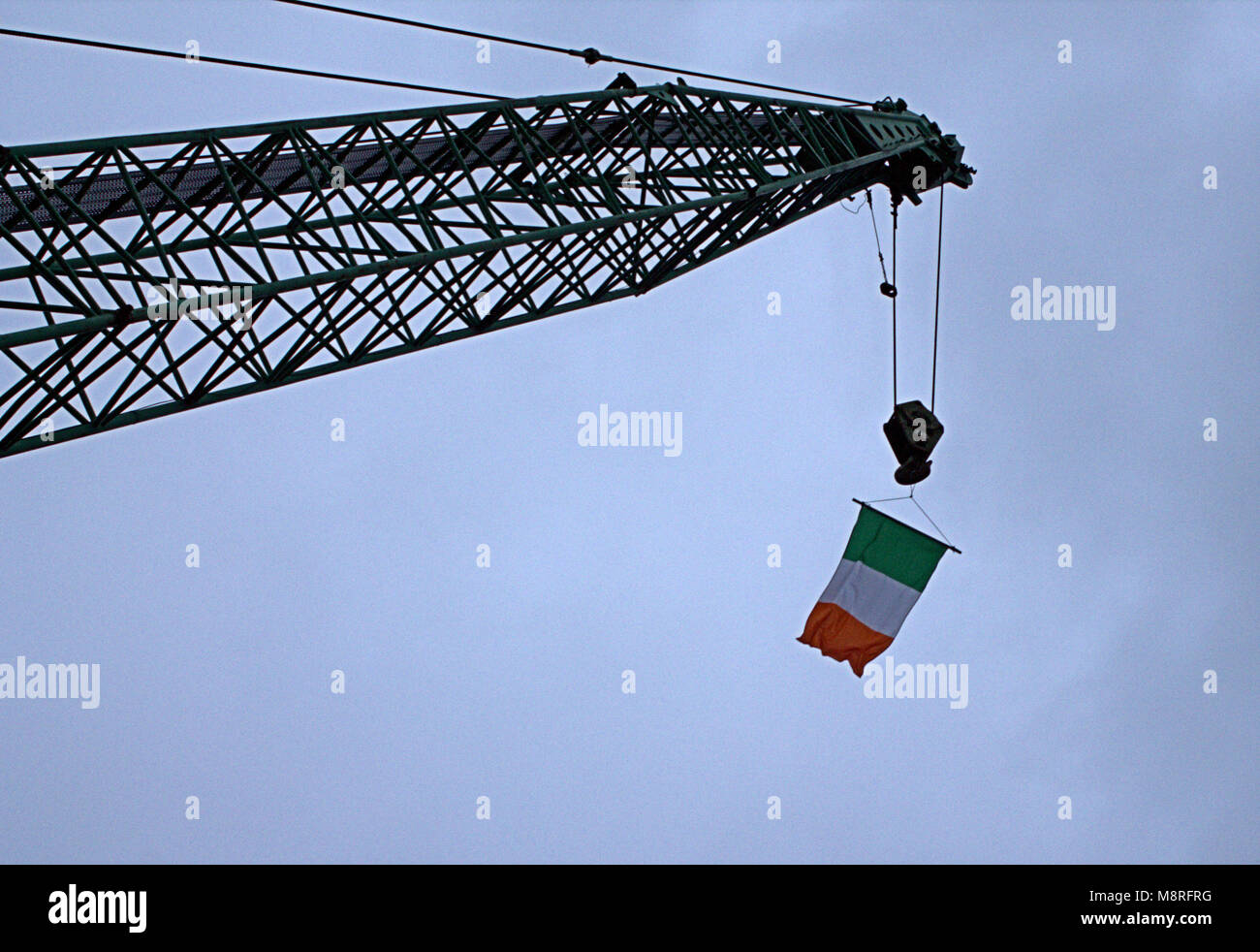 Braccio di gru, jib battenti Irlanda bandiera nazionale su il giorno di san patrizio.Skibbereen, West Cork, Irlanda Foto Stock