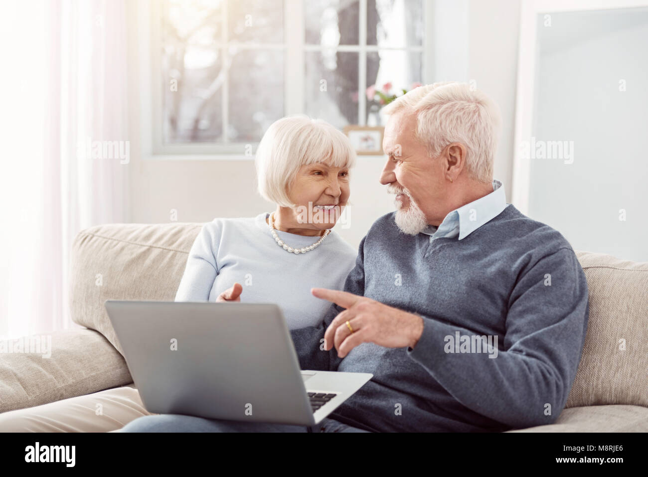 Felice coppia di anziani discutendo articolo online insieme Foto Stock