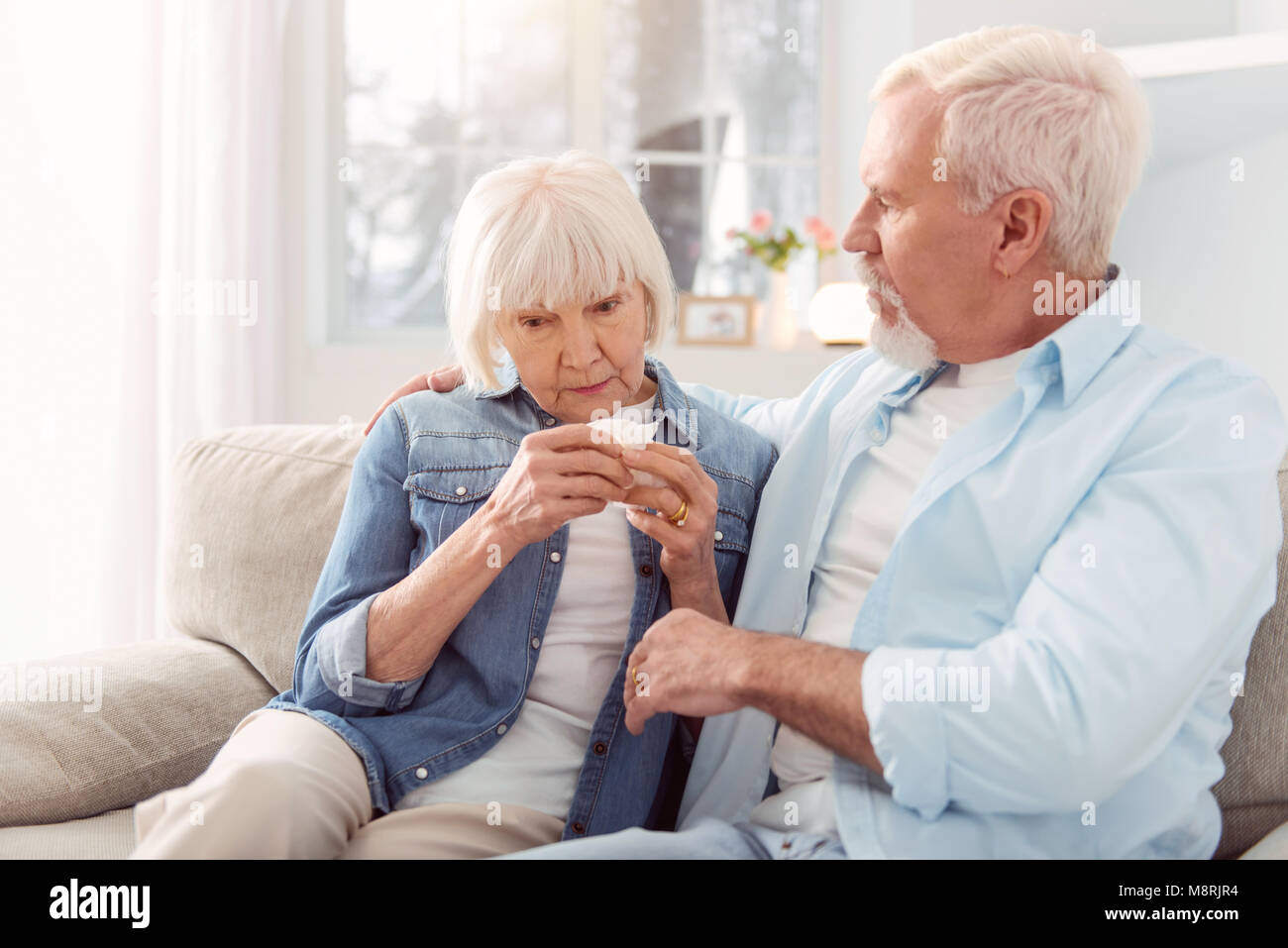Cura uomo anziano consolante la sua moglie di pianto Foto Stock