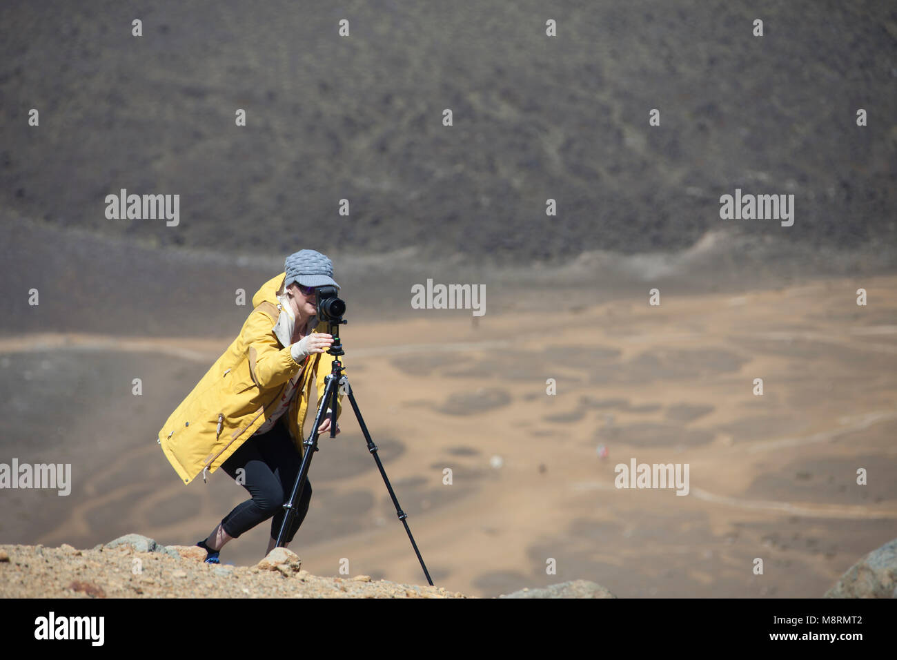Donna di fotografare con la fotocamera sul cavalletto presso il desert Foto Stock