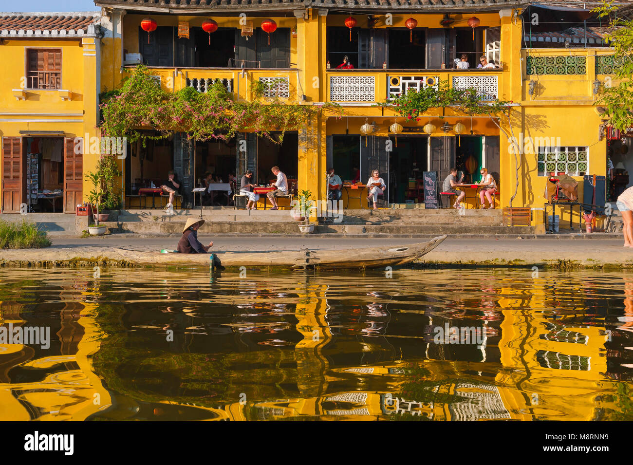 I turisti di Hoi An in Vietnam, ammirano al tramonto i turisti che si rilassano in un bar sul lungomare accanto al fiume Thu Bon nel quartiere della città vecchia di Hoi An, in Vietnam. Foto Stock