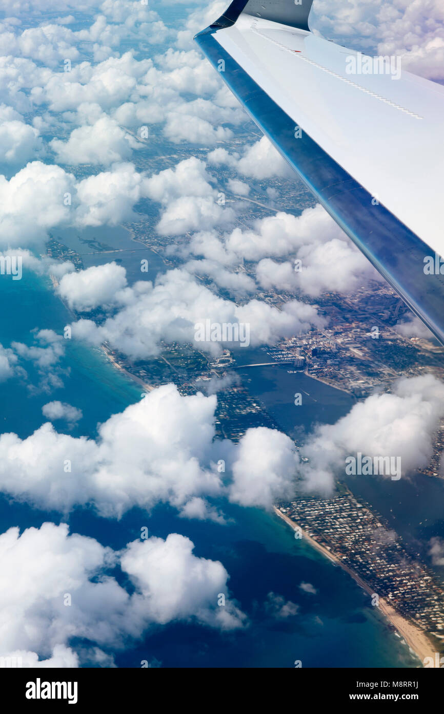 Close-up di ala di aeromobile che vola in cielo molto nuvoloso sulla città e sul mare Foto Stock Close-up di ala di aeromobile che vola in cielo molto nuvoloso sulla città e sul mare Foto Stock