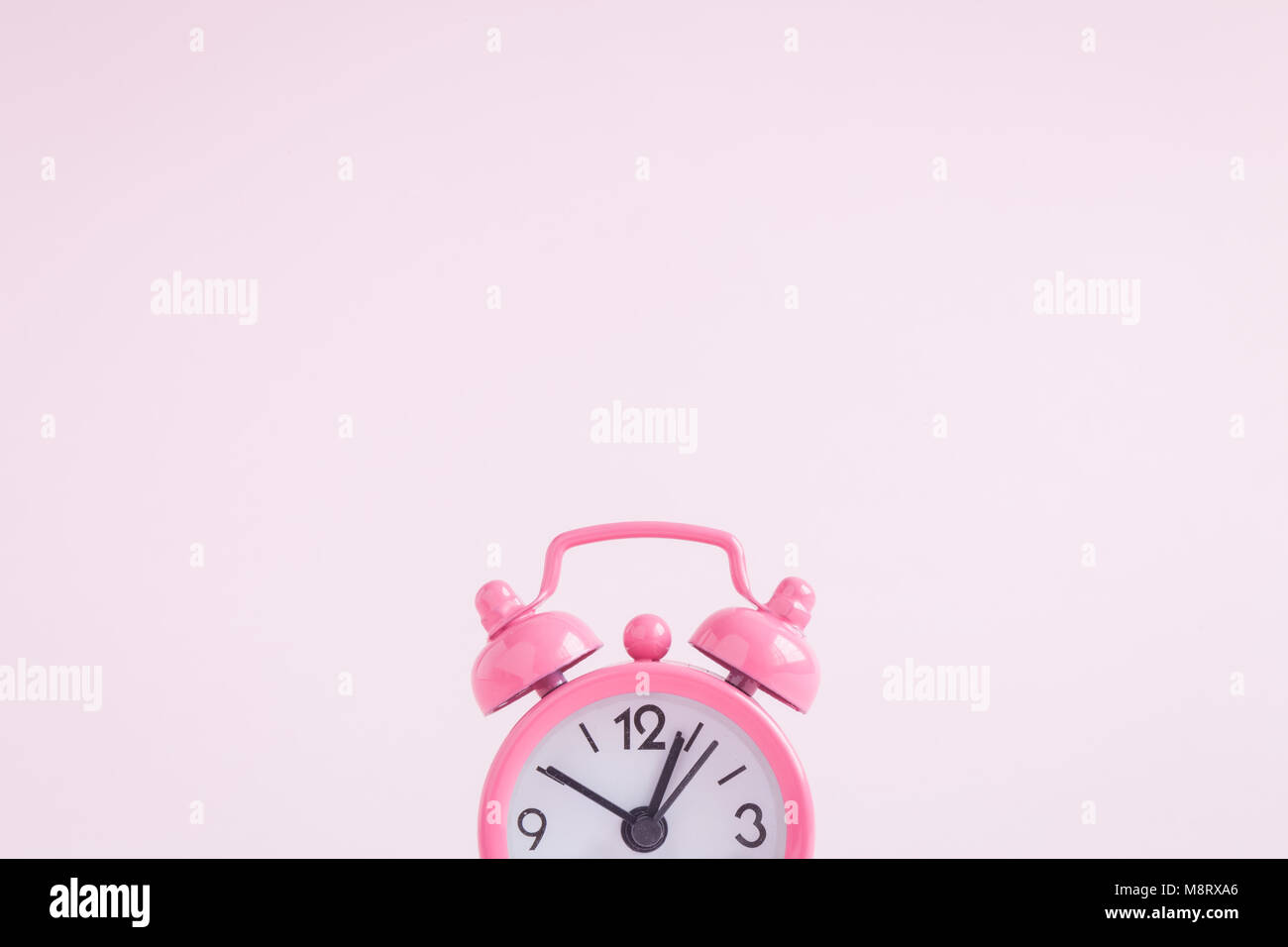 Sveglia del pastel pink background. Spazio per la copia. La minima nozione. Foto Stock