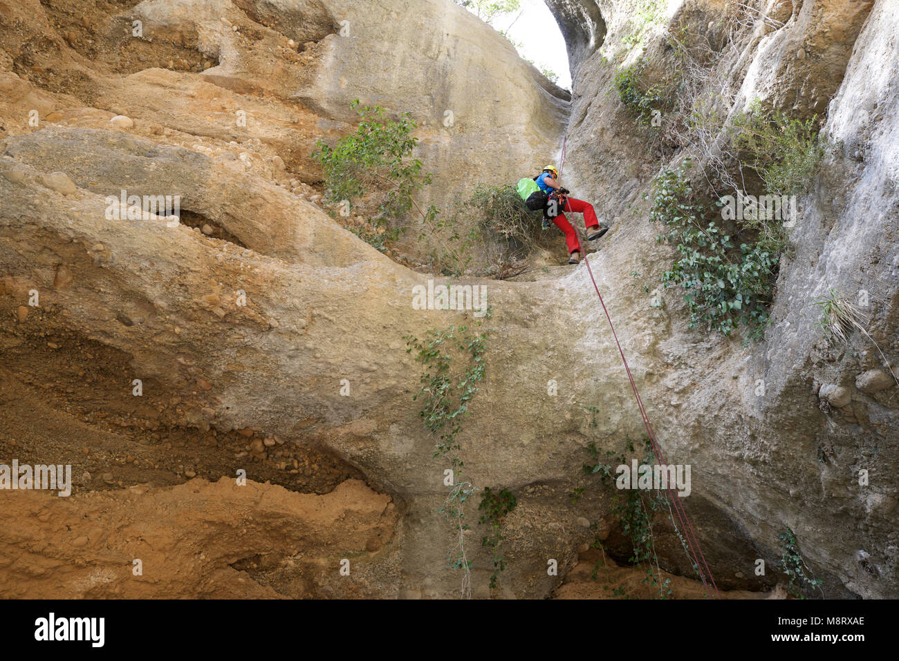 Basso angolo di visione dei maschi di escursionista --con zaino montagna arrampicata Foto Stock