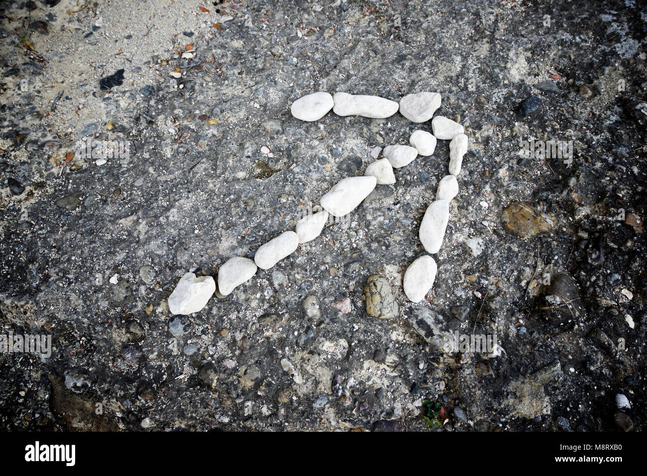 Alta Vista angolo di freccia con il simbolo realizzata con ciottoli di fiume Foto Stock