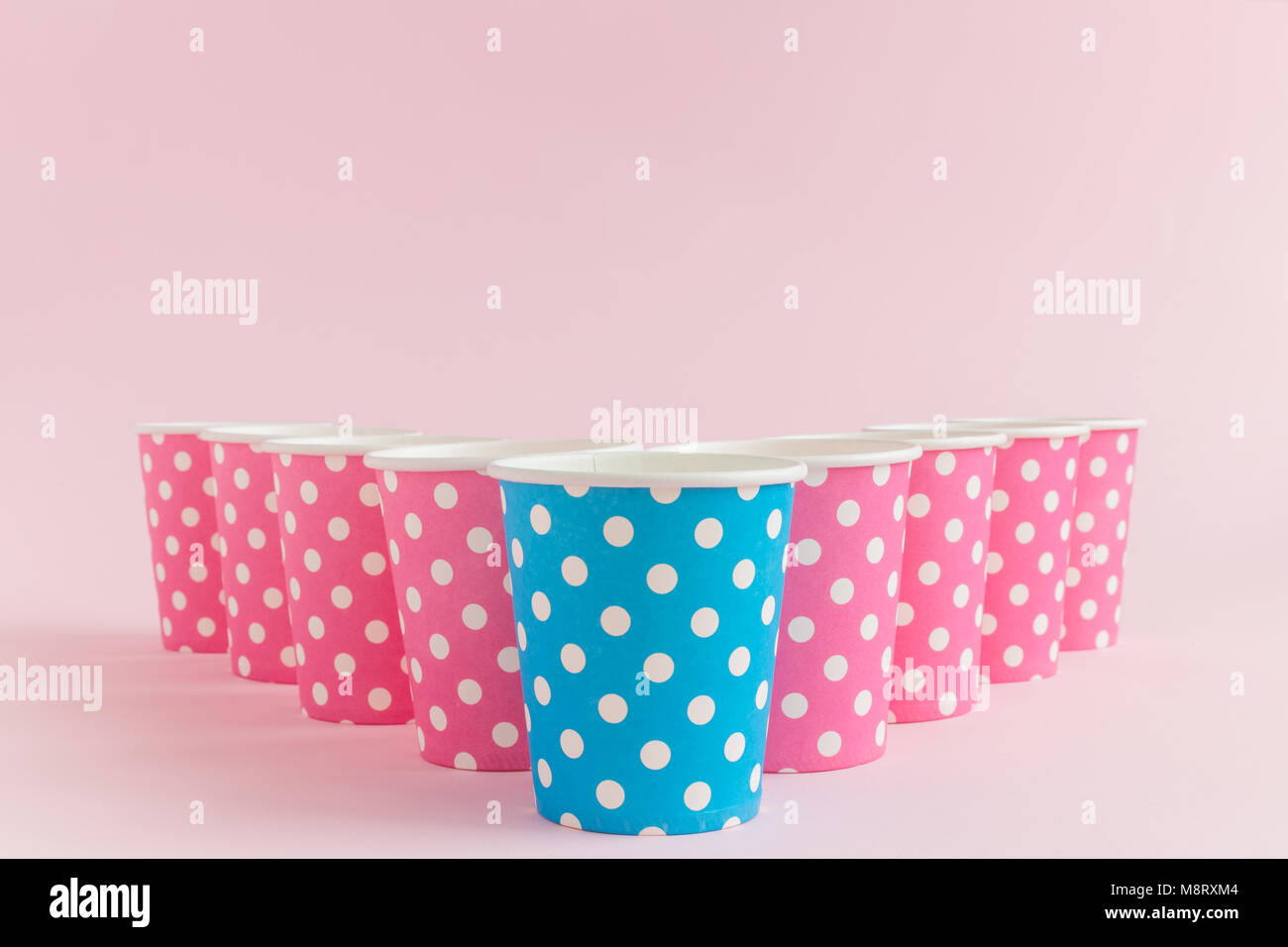 Bicchieri di carta polka design contro di rosa pastello minima di sfondo concetto creativo Foto Stock