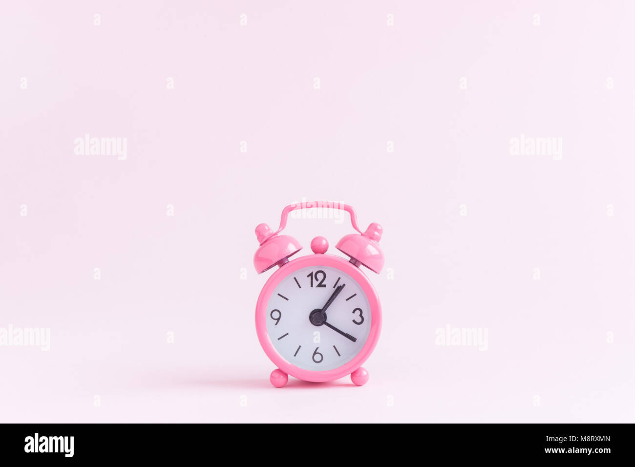 Sveglia del pastel pink background. Spazio per la copia. La minima nozione. Foto Stock