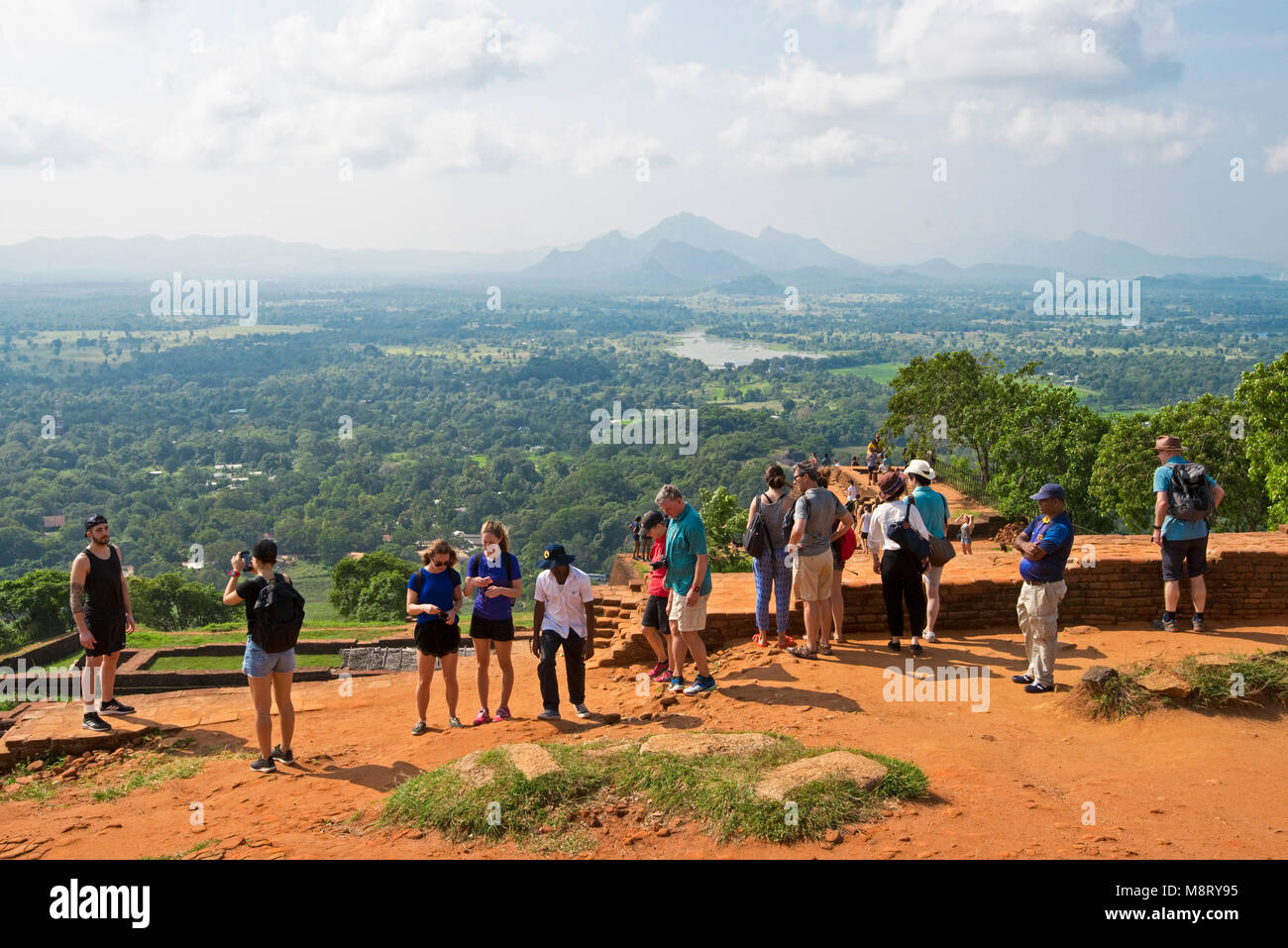 Una vista di turisti sulla cima di Sigiriya guardando la vista o scattare foto fotografie in una giornata di sole. Foto Stock