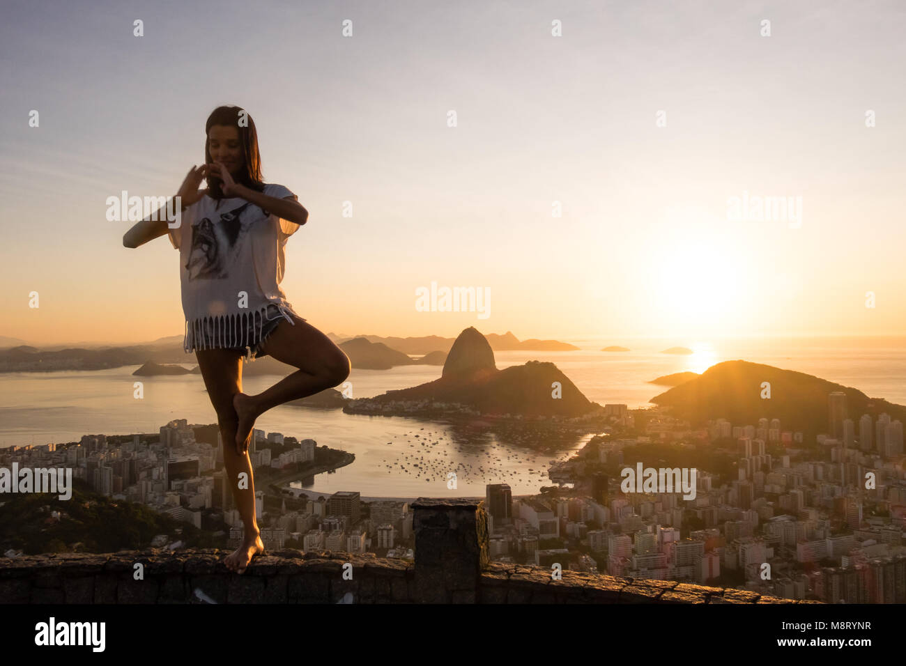 Ragazza a praticare Yoga posizioni Sunrise Mirante Dona Marta, Rio de Janeiro, Brasile Foto Stock