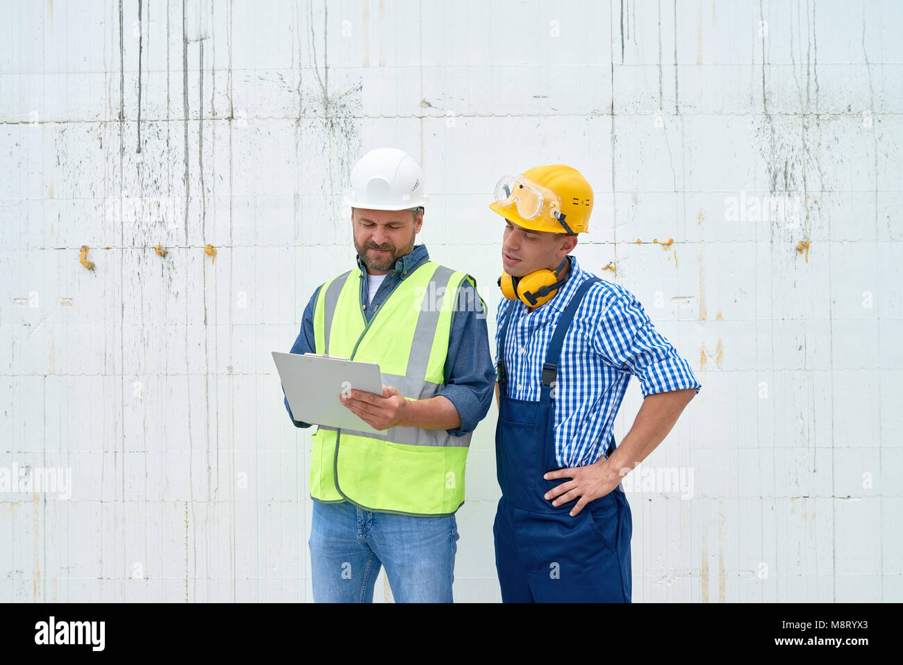 Lavoratori edili a discutere di costruzione Foto Stock