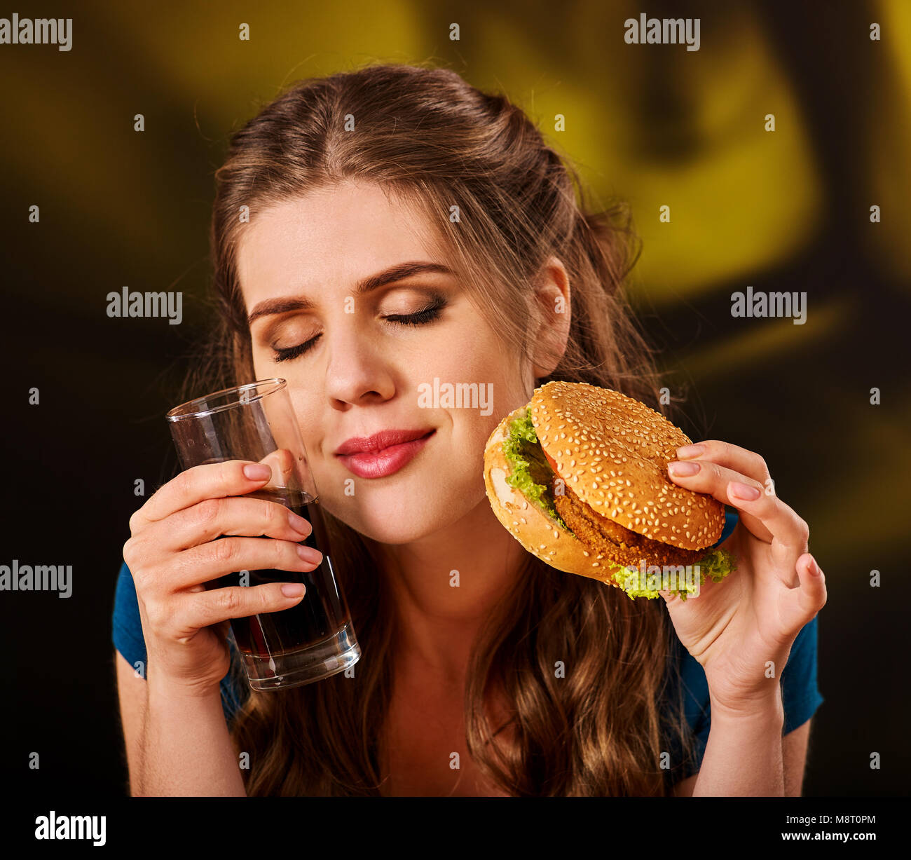 Donna di mangiare patatine e hamburger. Foto Stock
