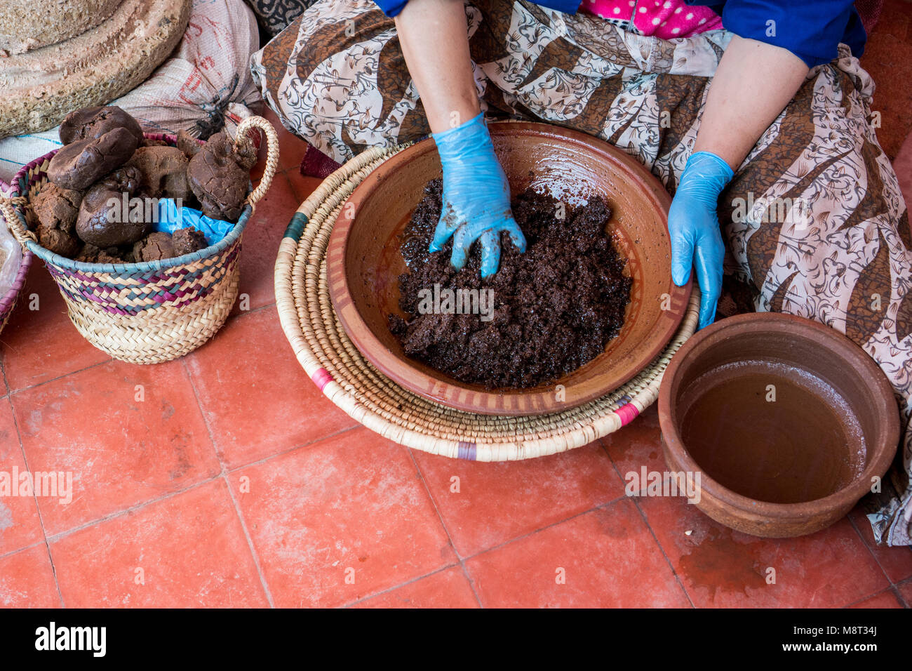 Le donne musulmane rendendo l'olio di argan in modo tradizionale in Marocco. La produzione tradizionale di olio di argan utilizzato per i prodotti cosmetici e per la preparazione dei prodotti alimentari Foto Stock