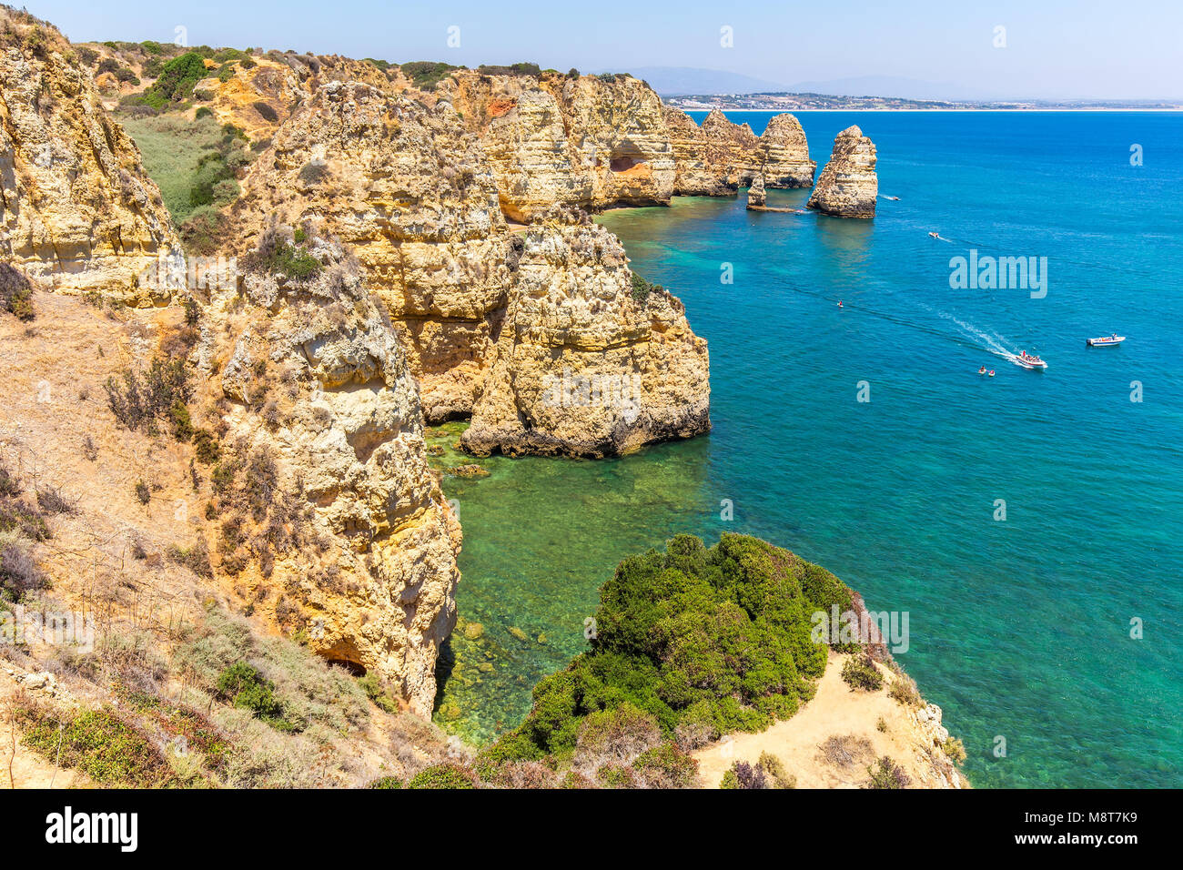 Costa portoghese con montagne rocciose blu del mare e le barche Foto Stock