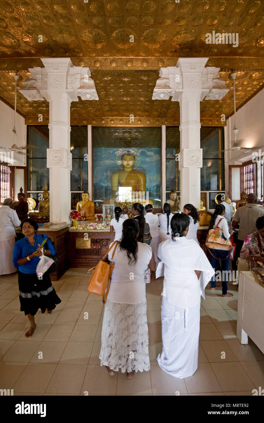 La popolazione locale e i pellegrini pregano e dando Regali di fiori all'Jaya Sri Maha Bodhi in Anuradhapura, Sri Lanka. Foto Stock