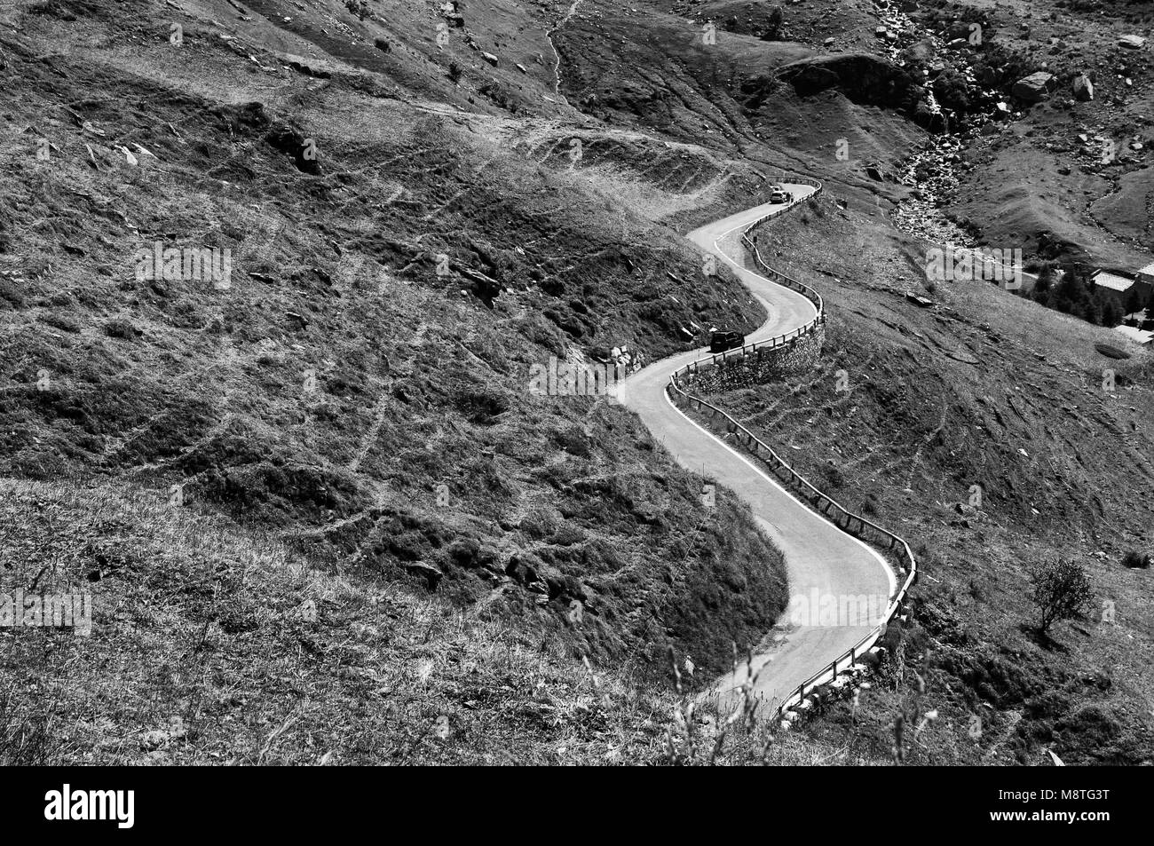 Paesaggio percorso turistico avvolgimento iconica strada curva immagine in bianco e nero Italia Piemonte Alpi circa nel settembre 2013 Foto Stock