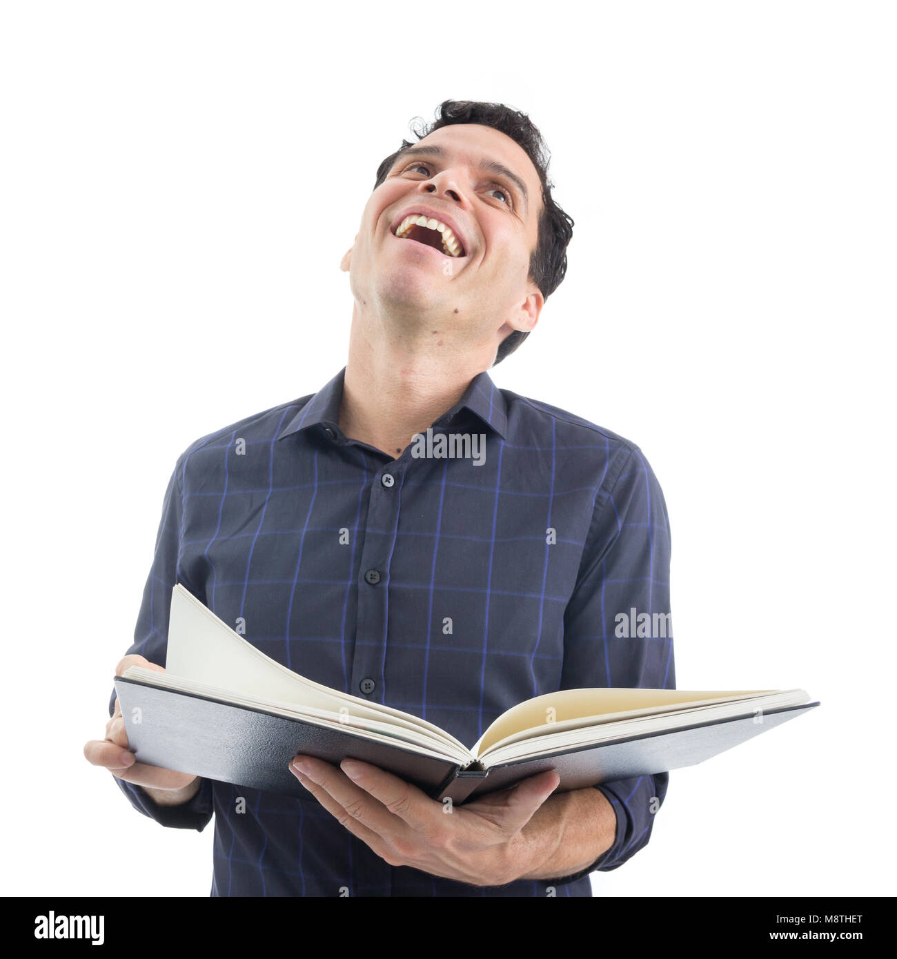 Uomo sorridente è divertirsi leggendo il libro. La persona è Caucaso e indossa blue button down shirt. Isolato. Sfondo bianco. Foto Stock