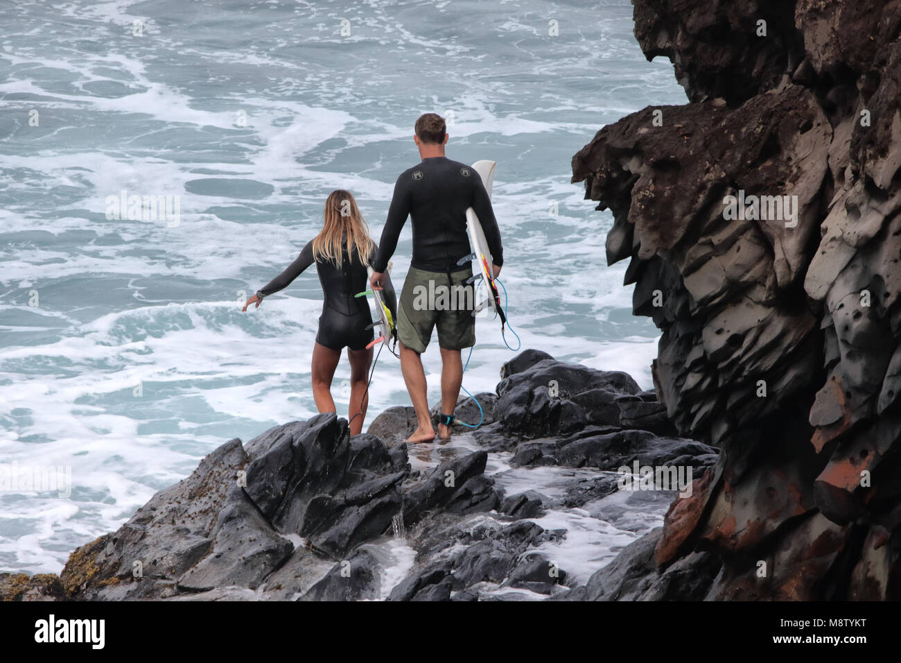 Coppia giovane pronta ad entrare il surf presso la Baia Honolua a Maui. Foto Stock