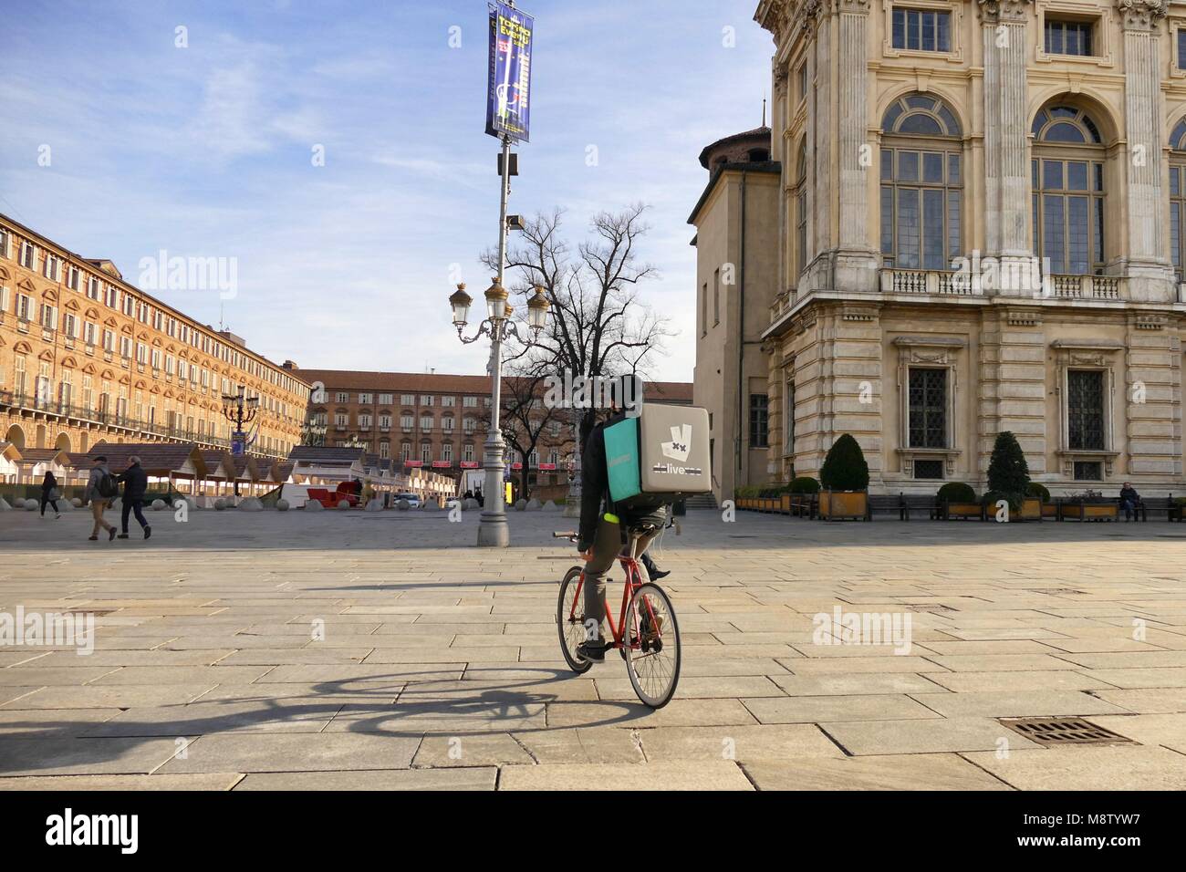 Deliveroo Consegna del cibo bike runner vista panoramica nella storica piazza logo modificato mediante il biker per mostrare solo vivere la parola Torino Italia 18 Gennaio 2018 Foto Stock