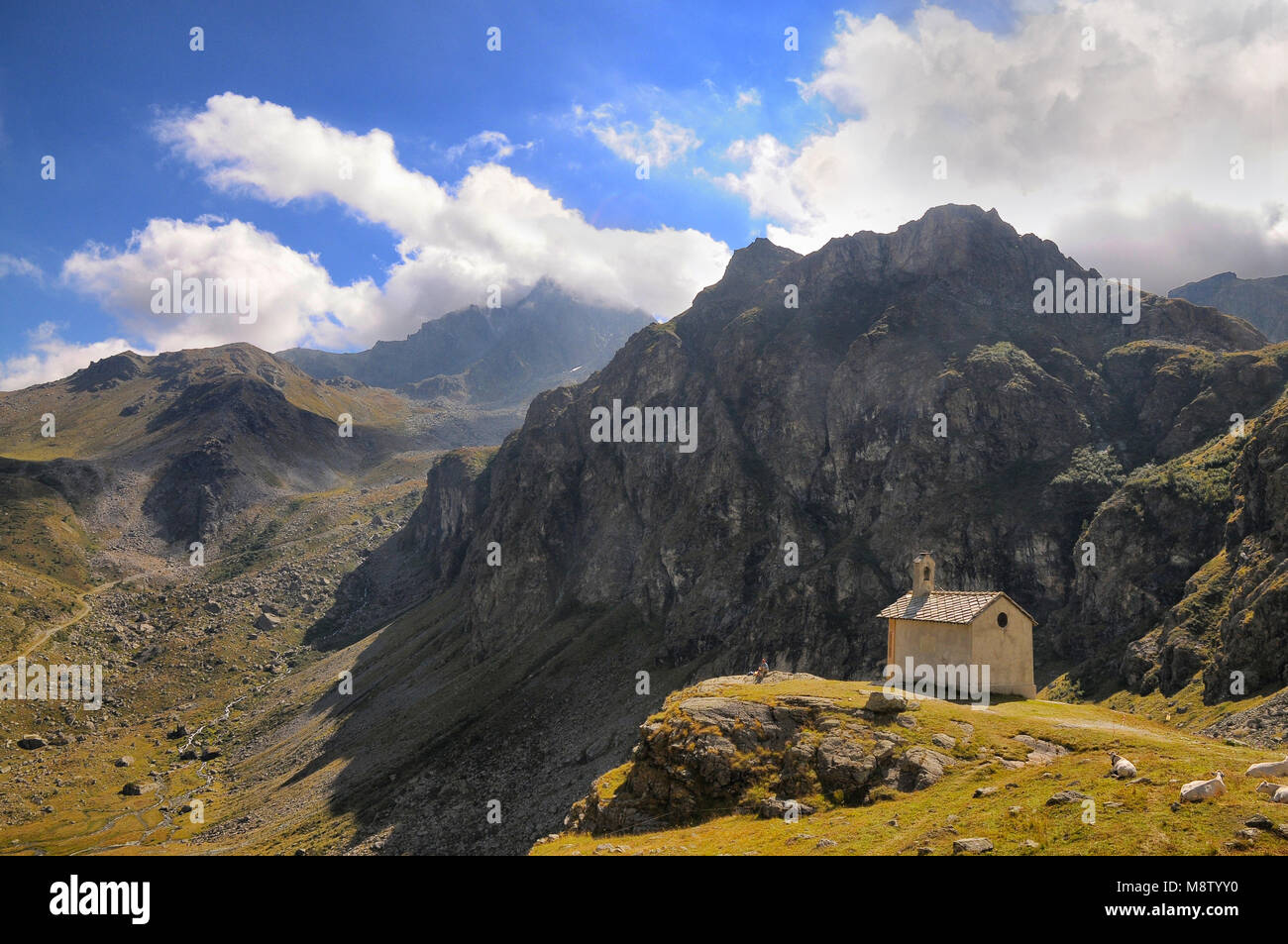 Escursionista solitario poggia su di un picco di contemplare il paesaggio vista panoramica delle Alpi Italia circa nel settembre 2013 Foto Stock