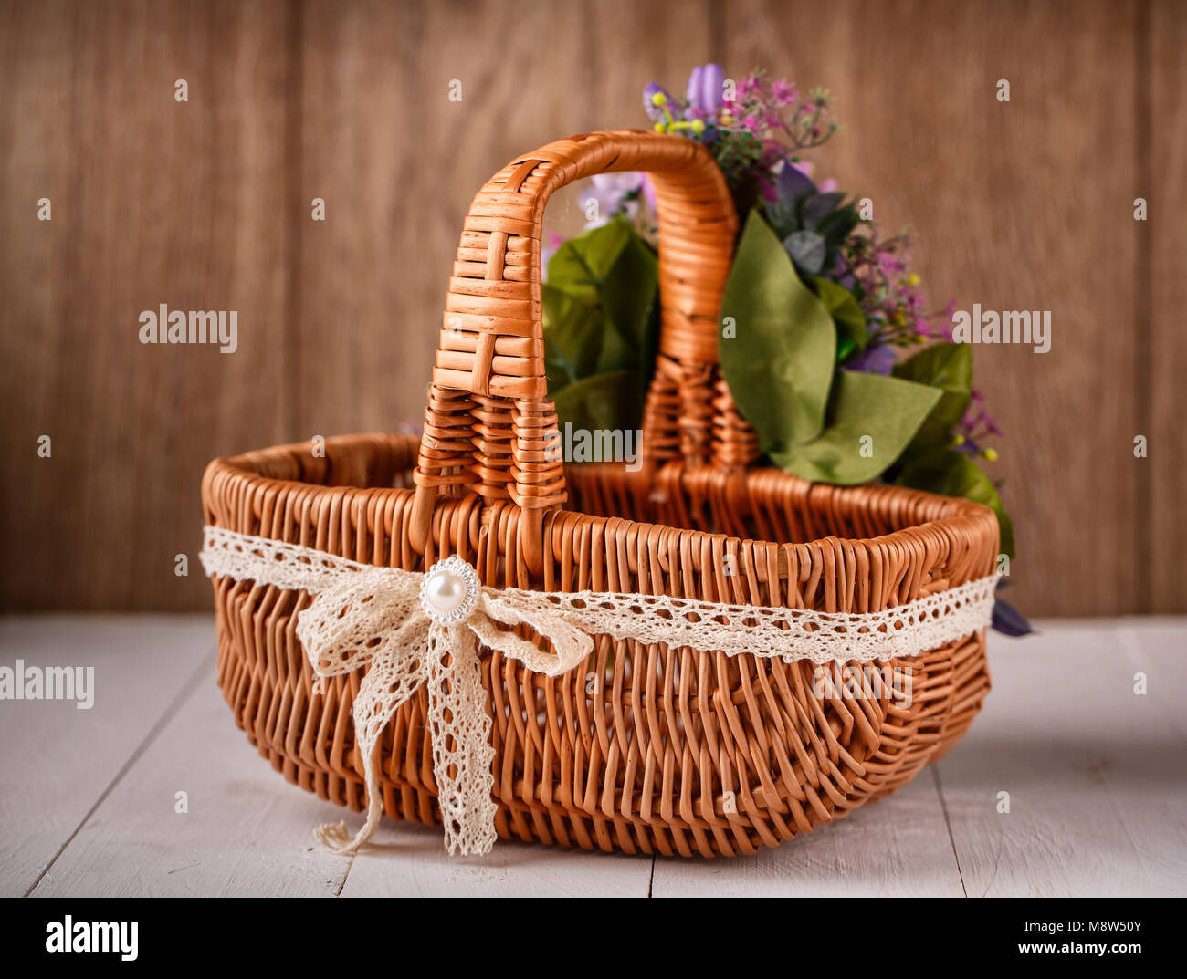 Originariamente decorato da fiori cesto su uno sfondo di legno Foto Stock