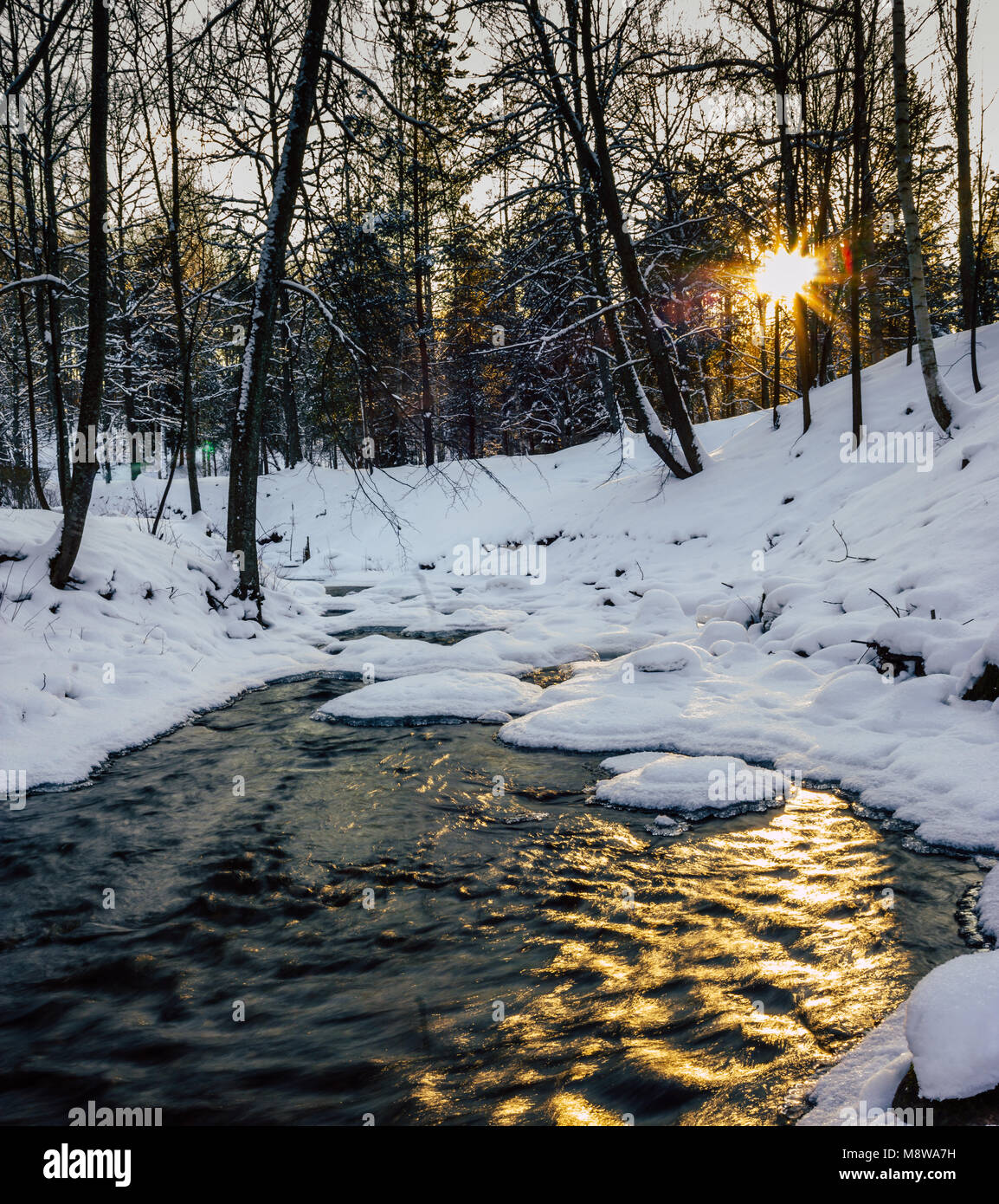 Calma Inverno Foto di un parzialmente Frozen River con un sole che splende nella fotocamera, fare bella bella e Sun Star - Sun Flare Foto Stock