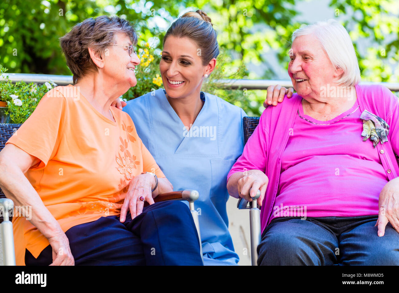Infermiera geriatrica avente chat con le donne anziane in casa di riposo Foto Stock